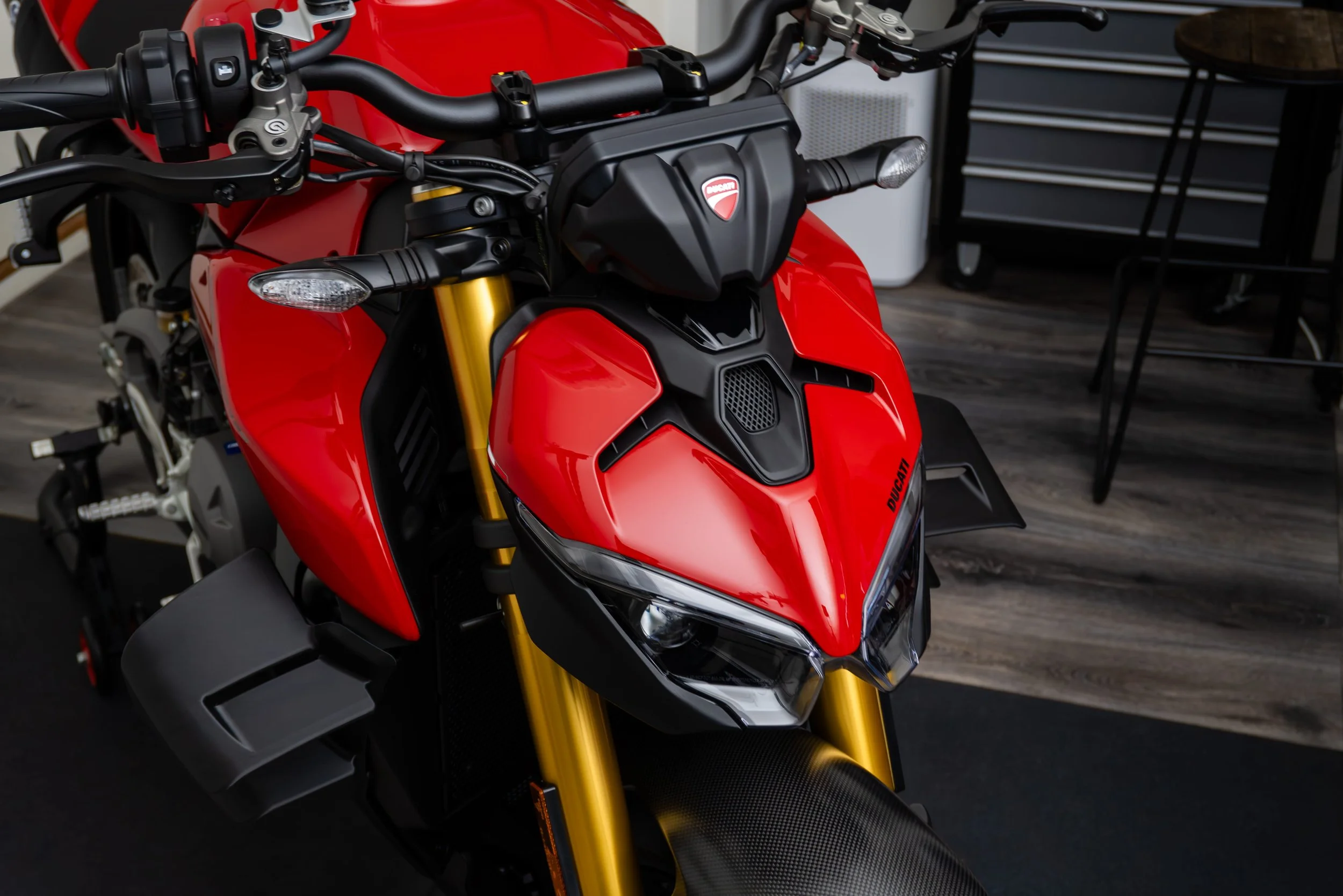Close-up of the front a red Ducati motorcycle after paint correction and ceramic coating, inside our motorcycle detailing studio.