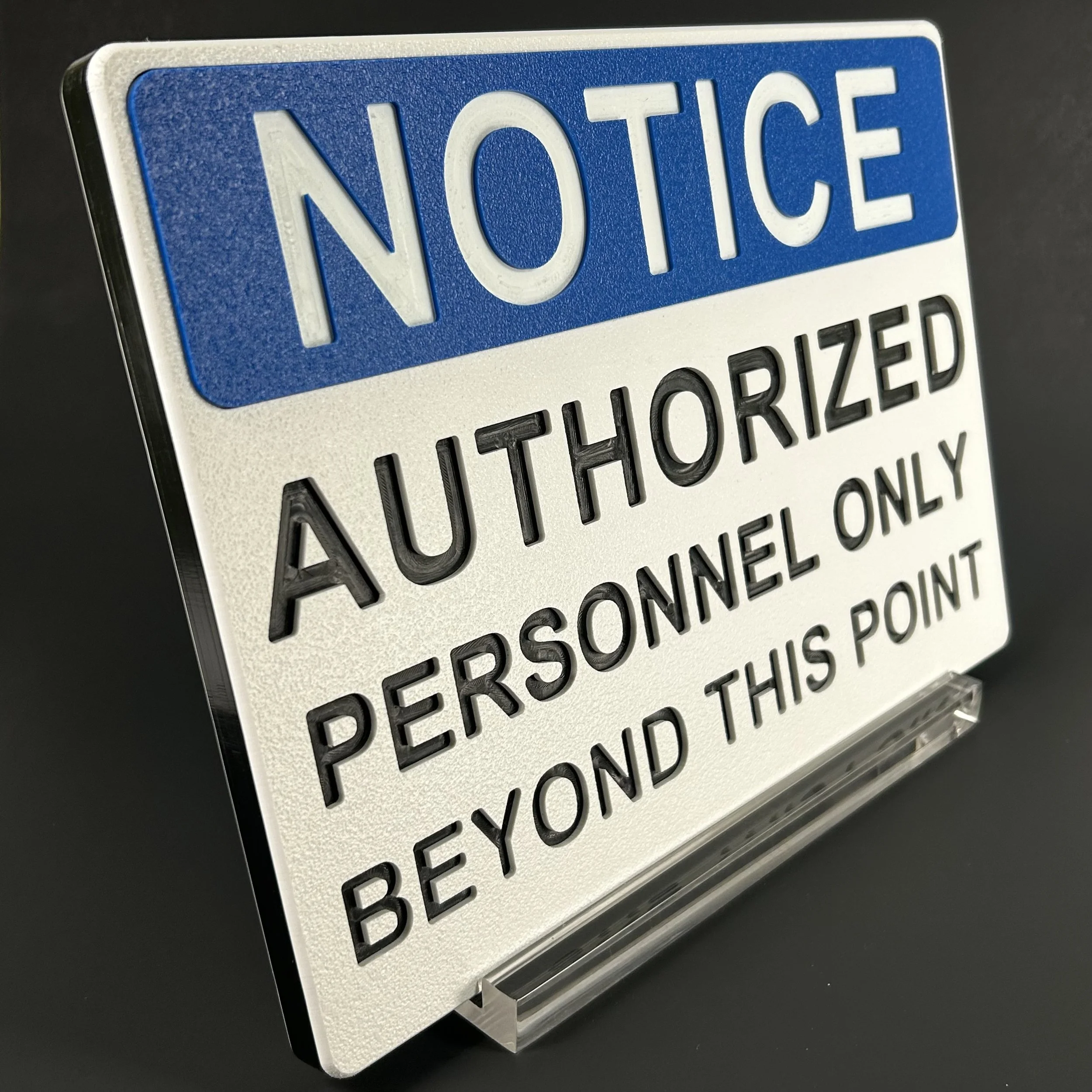 Close-up of a police or security sign with blue and white background, featuring the word 'NOTICE' in bold letters, designed for alerting or informing the public.