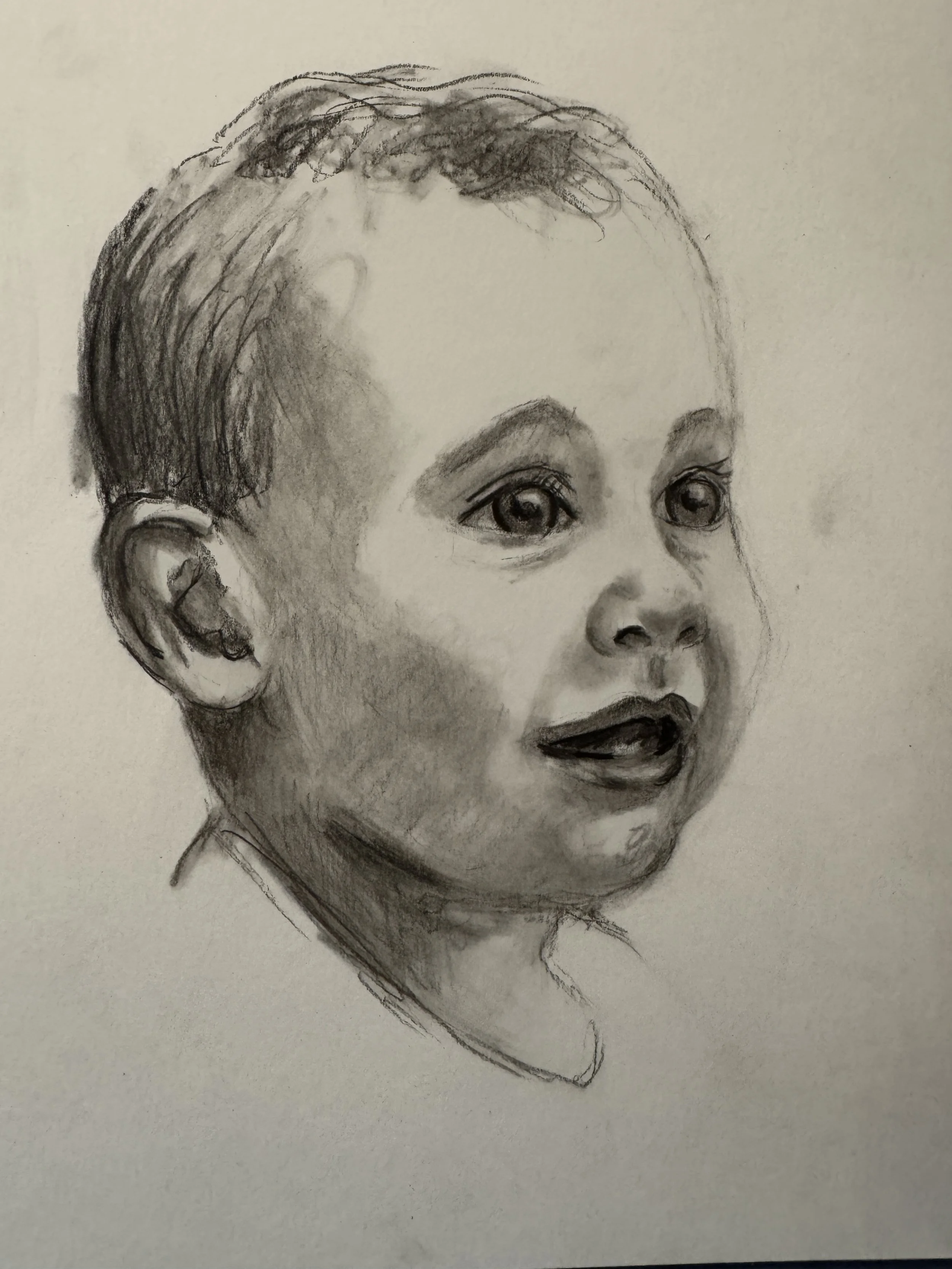 Black and white sketch of a young child's face, showing expressive eyes, short hair, and a slightly open mouth.