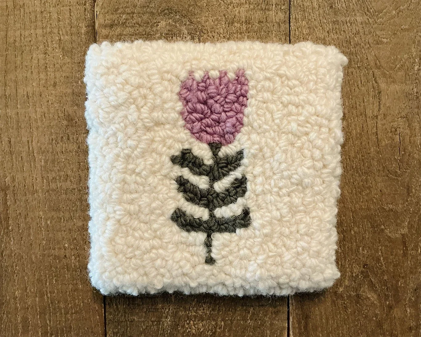 Hand-hooked wool panel in ivory featuring stylized lavender bloom with green stem.