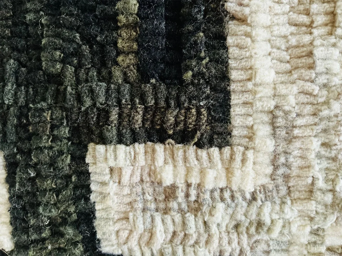 Detail of hand-hooked wool texture forming the Nordic cross motif.
