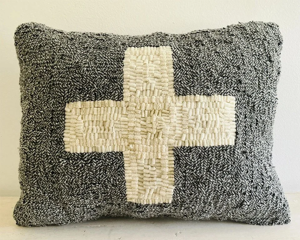 Charcoal gray hand-hooked wool pillow with an ivory Nordic cross motif.