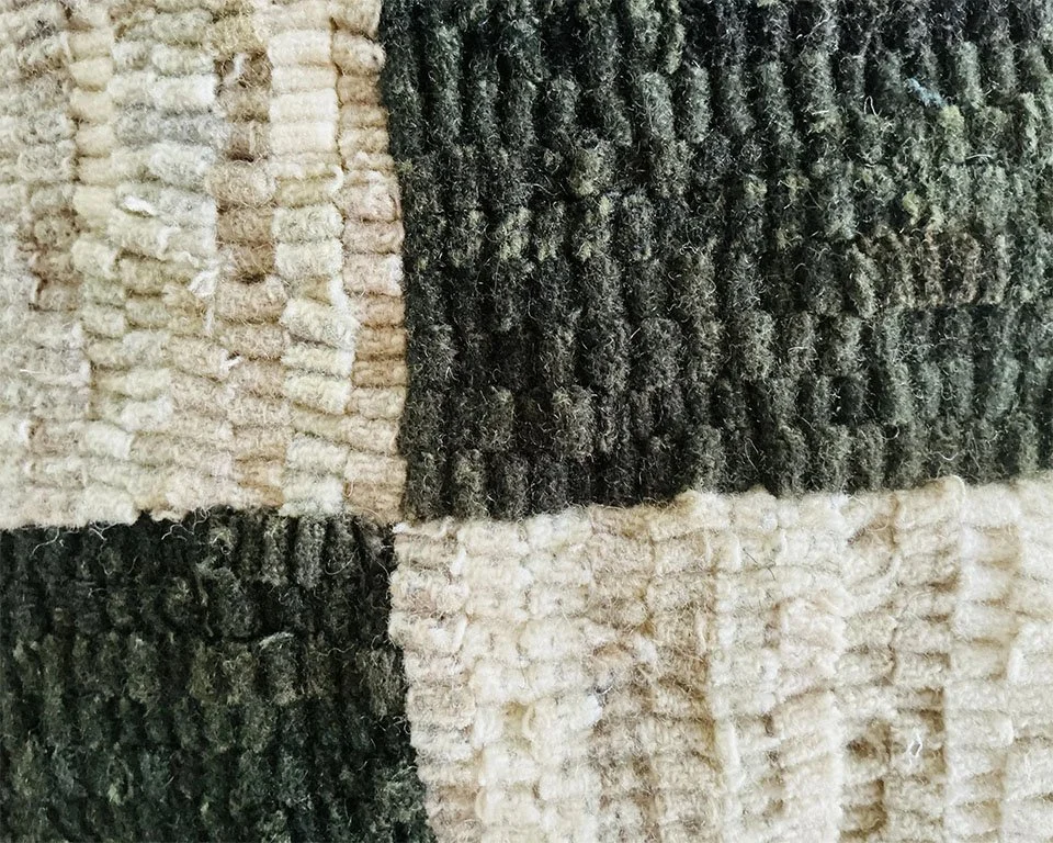 Detail of wool pillow showing varied loop height and subtle tonal striation.