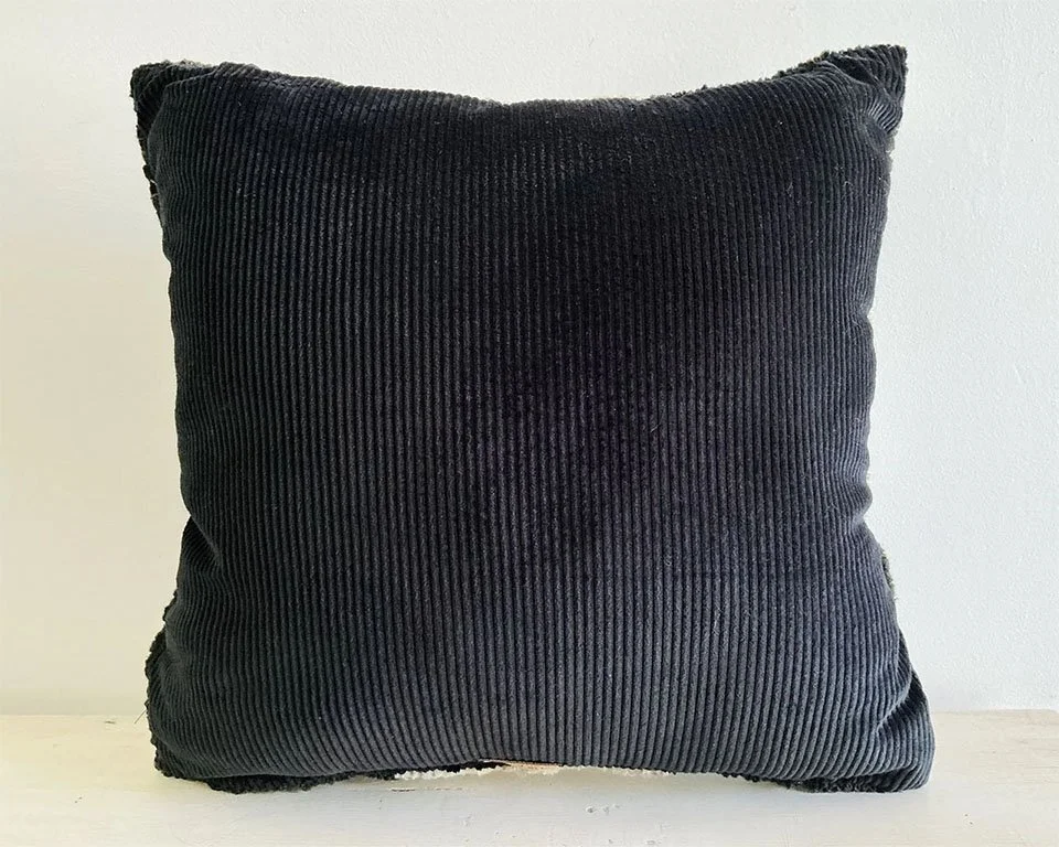 Back of pillow in charcoal cotton corduroy fabric.