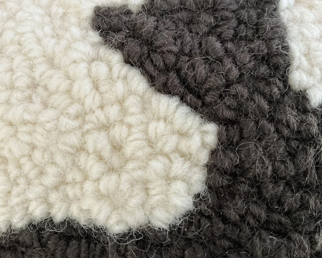 Detail of hand-hooked wool showing the moose against the ivory ground.
