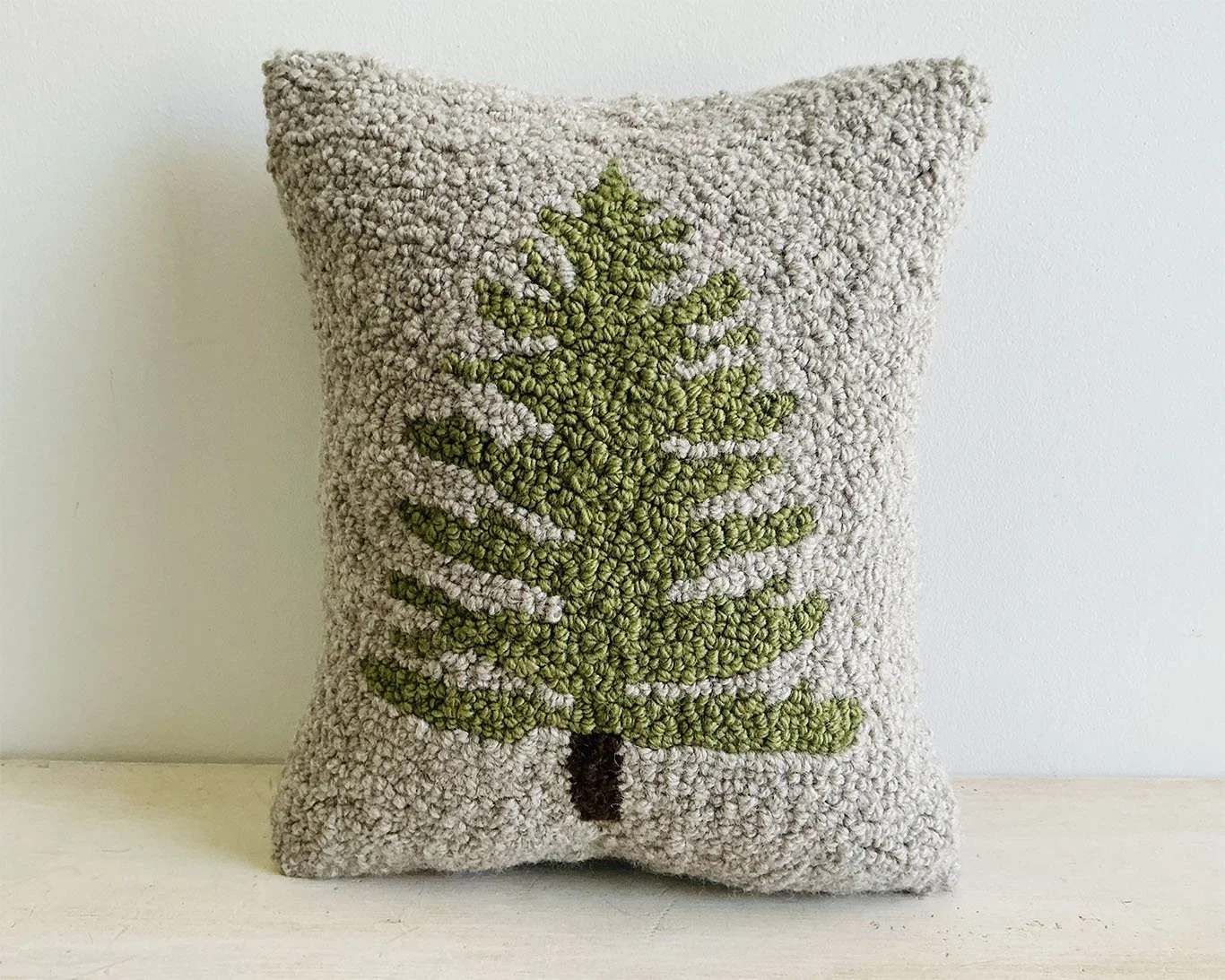 Natural hand-hooked wool pillow with an evergreen tree in moss green.