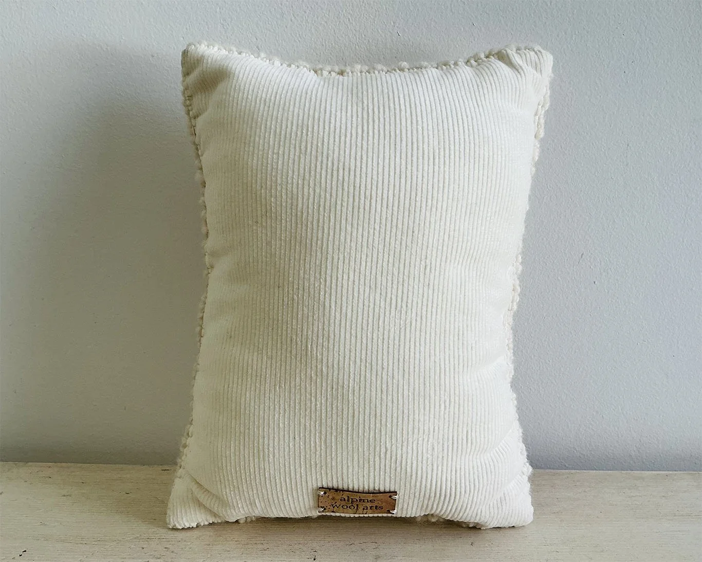 Back of pillow in ivory cotton corduroy fabric.