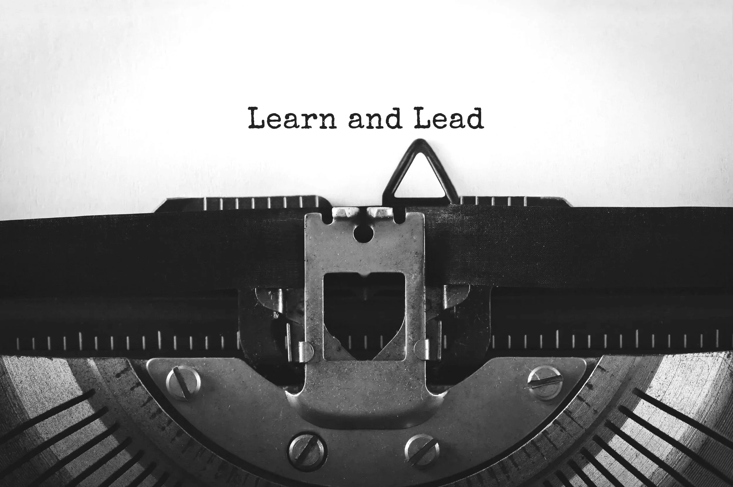 vintage typewriter with the words "Learn and Lead"