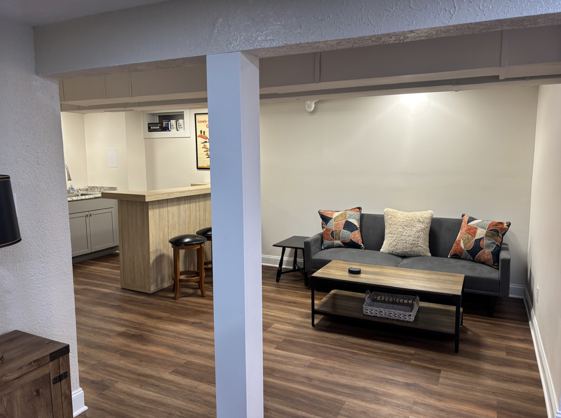 Side area of basement with couch and bar