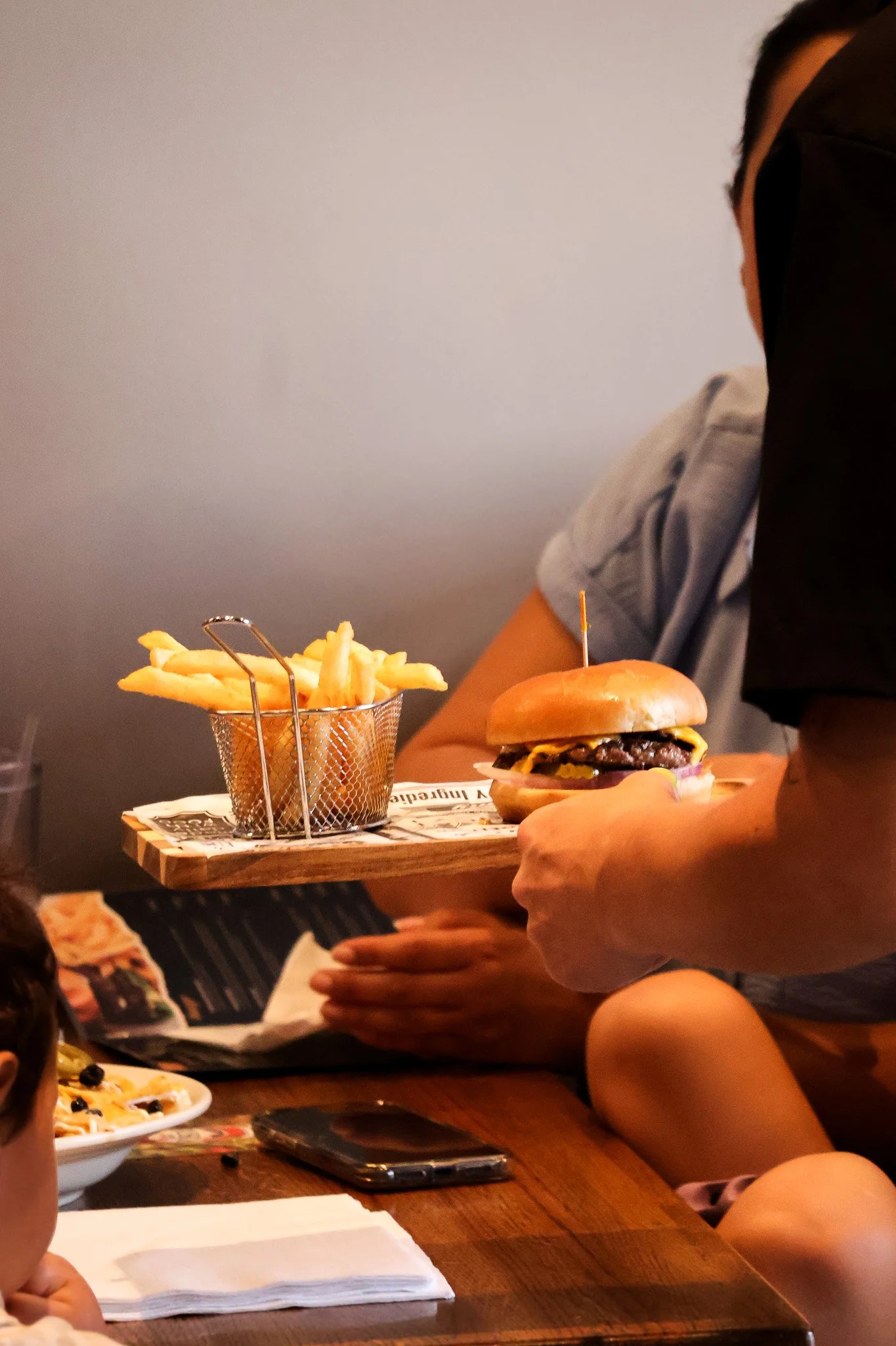 The Hangout waitress serving a burger