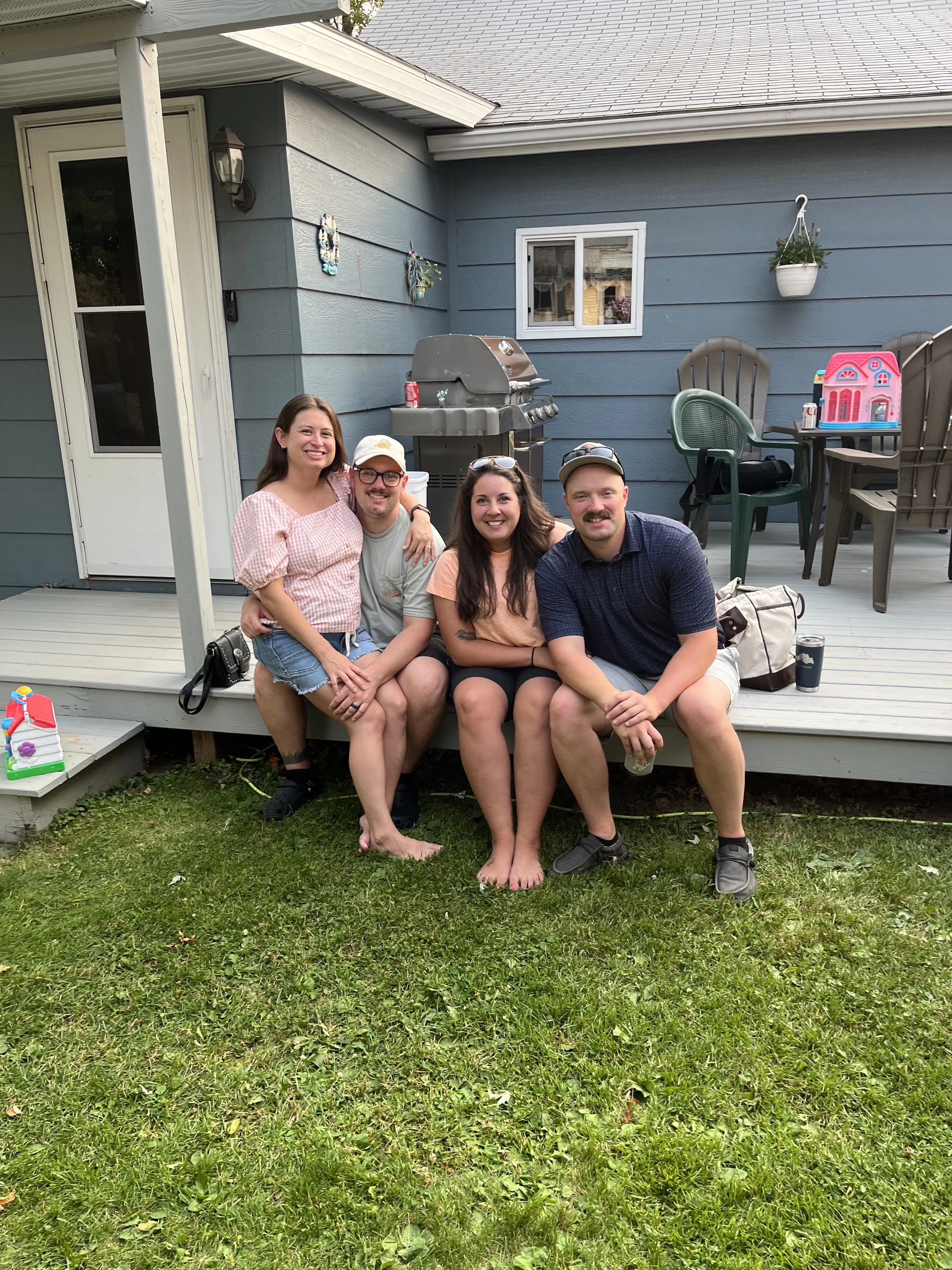 Family members sitting on back porch of blue house