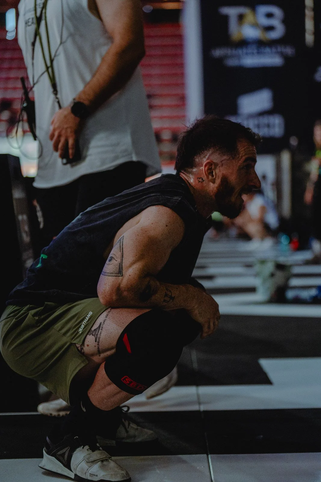 Homme souriant en squat avec genouillère dans une salle CrossFit à Bordeaux — photographe CrossFit Voar by Tim