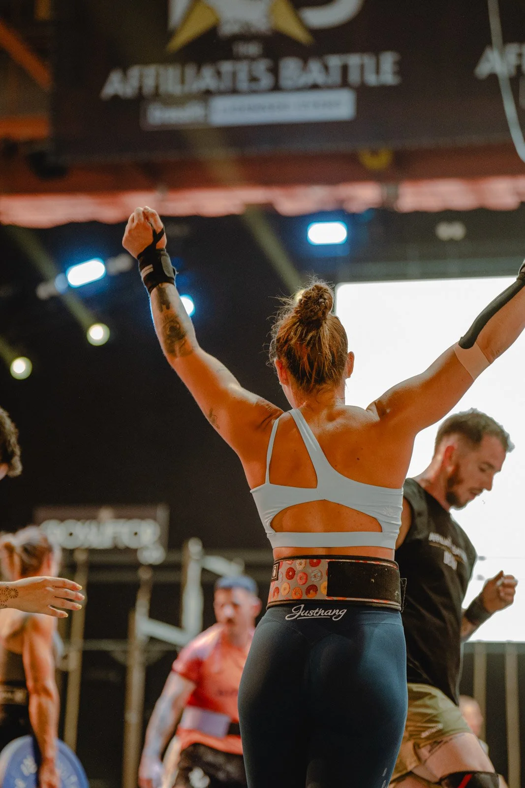 Athlète féminine bras levés célébrant une victoire dans une salle CrossFit à Bordeaux — photographe CrossFit Voar by Tim