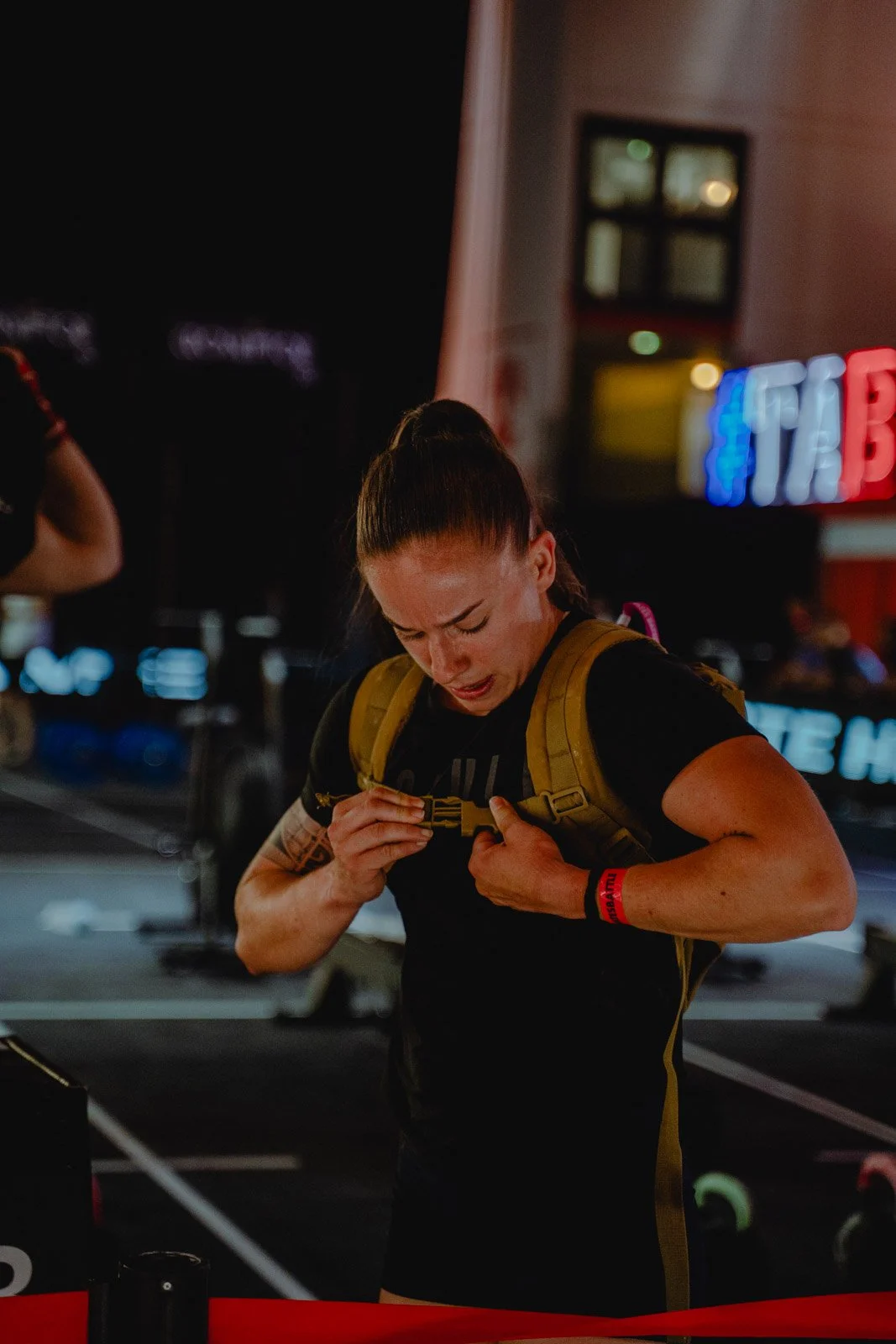 Femme avec sac à dos jaune lors d'une compétition CrossFit nocturne en Nouvelle-Aquitaine — photographe CrossFit Voar by Tim