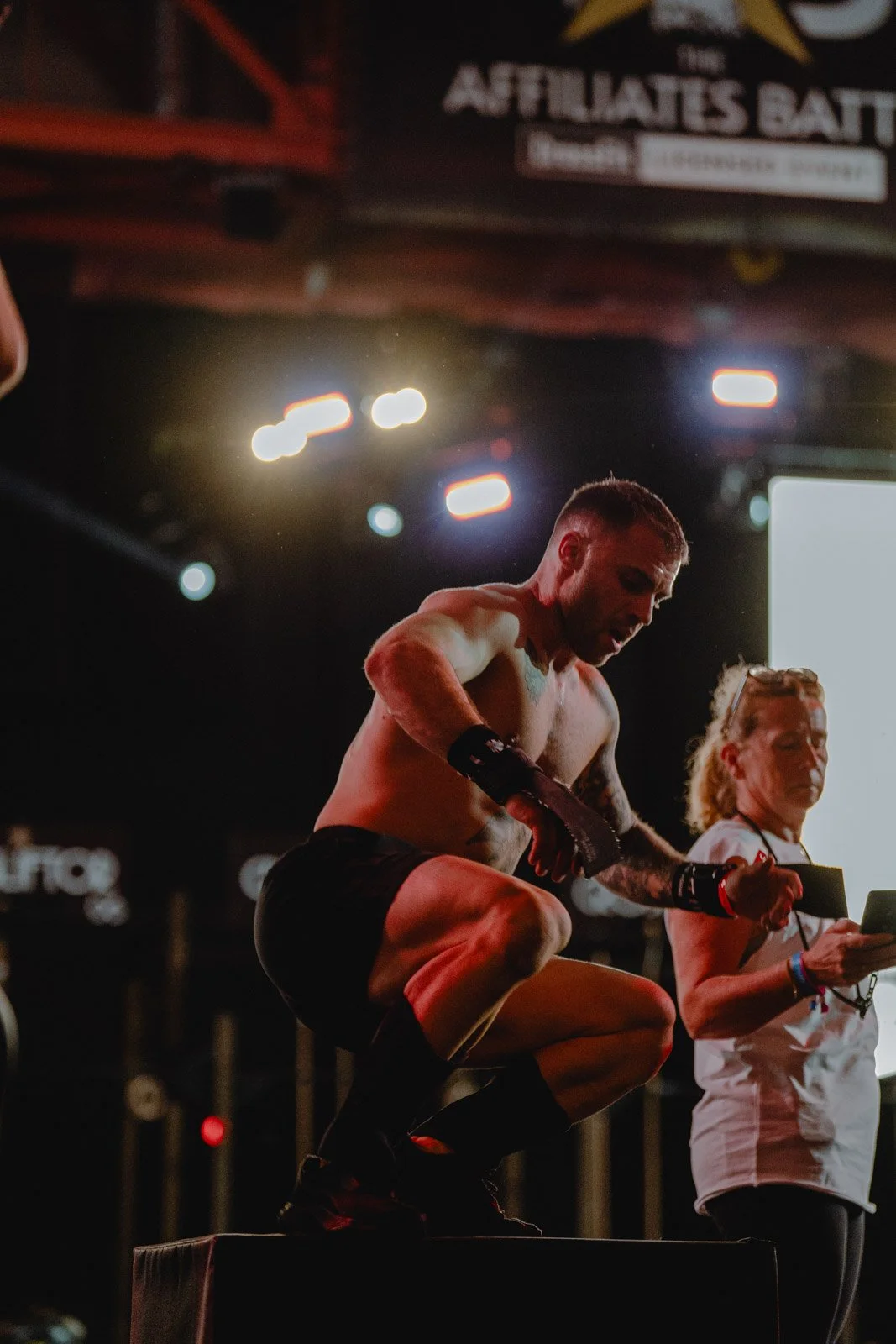 Homme torse nu sur podium avec présentatrice, cérémonie de remise de prix CrossFit Bordeaux — photographe CrossFit Voar by Tim