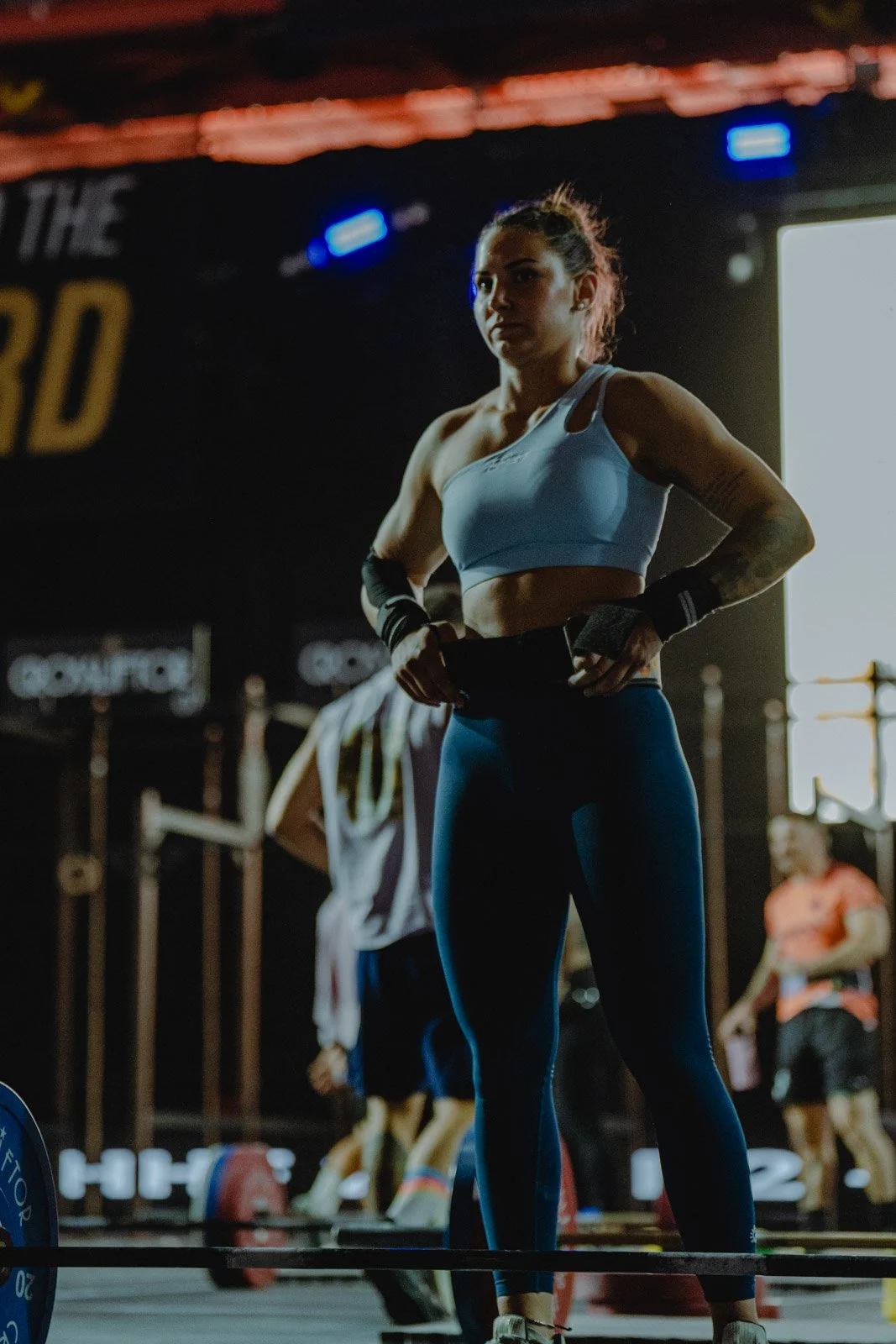Femme en tenue de sport dans une salle CrossFit entourée d'athlètes et équipements à Bordeaux — photographe CrossFit Voar by Tim