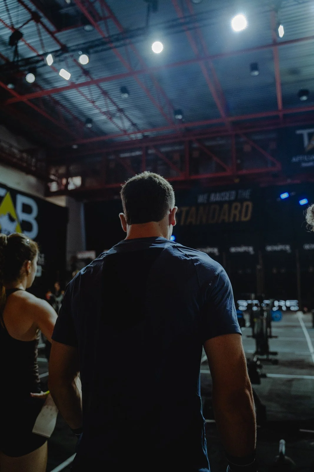 Groupe d'athlètes dans une salle CrossFit avec plafond en métal rouge à Bordeaux — photographe CrossFit Voar by Tim
