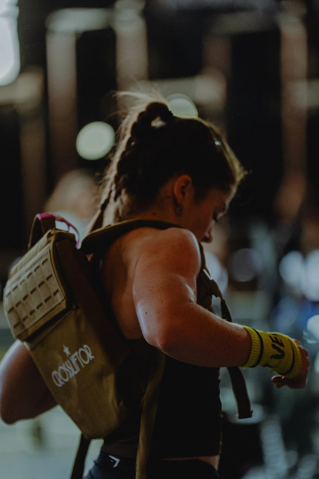 Femme avec sac à dos et bande de compression lors d'une compétition CrossFit nocturne à Bordeaux — photographe CrossFit Voar by Tim