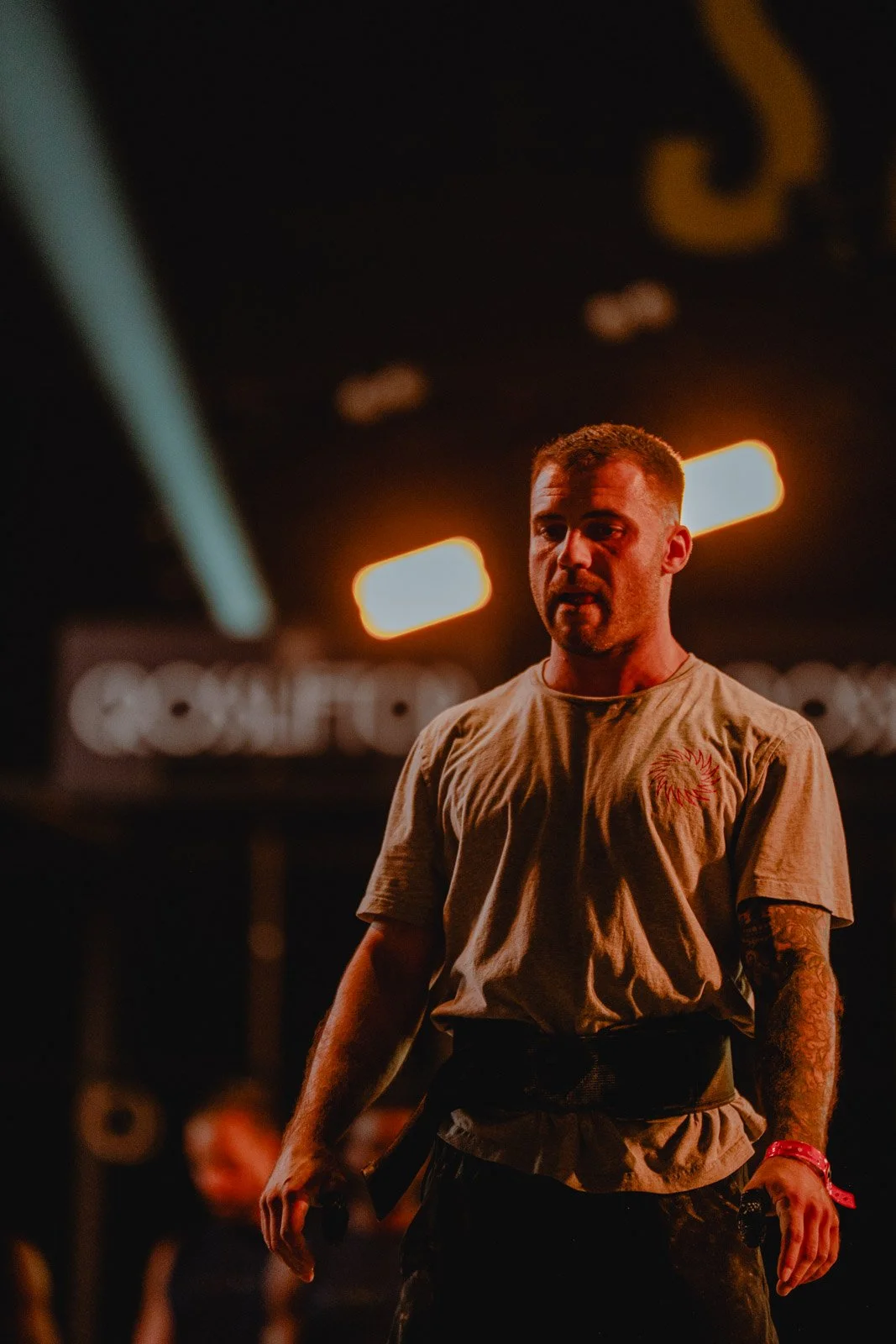 Homme debout avec t-shirt logo rouge dans une salle CrossFit sombre, Nouvelle-Aquitaine — photographe CrossFit Voar by Tim