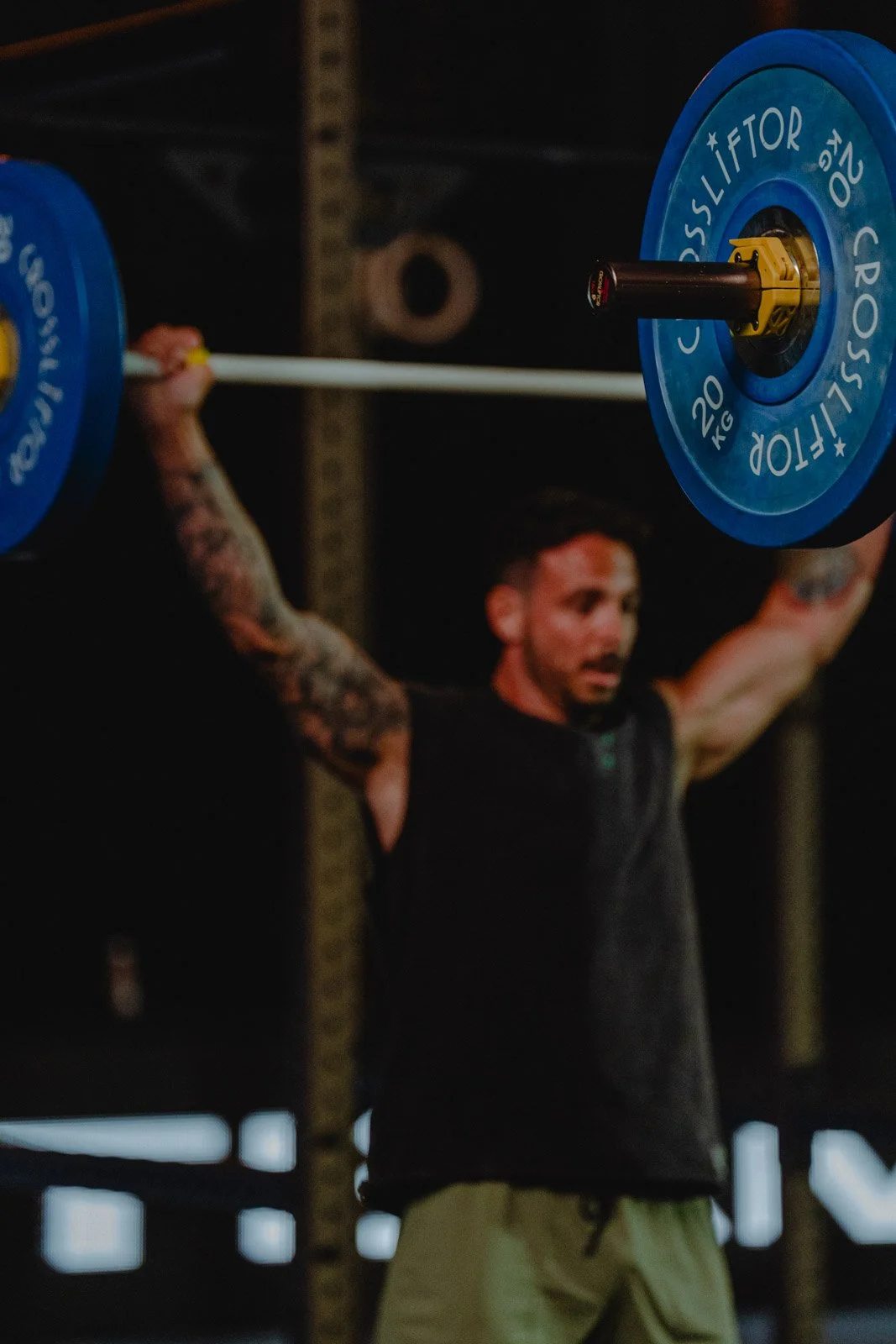 Homme soulevant une barre avec poids bleus lors d'une séance CrossFit en Nouvelle-Aquitaine — photographe CrossFit Voar by Tim