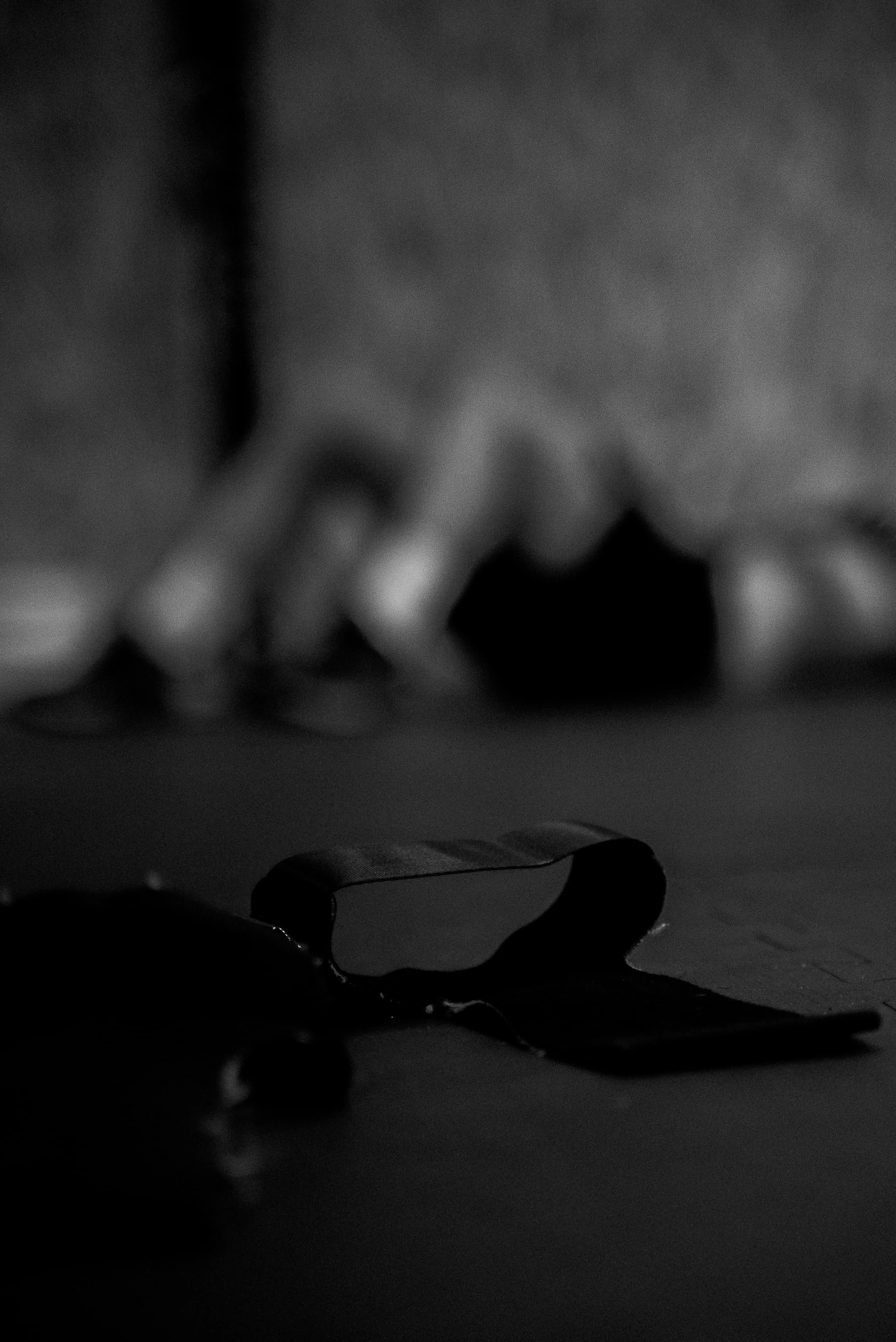 Une main tient une tablette ou un téléphone à l'horizontale, avec un fond flou de bulles. L'image est en noir et blanc.