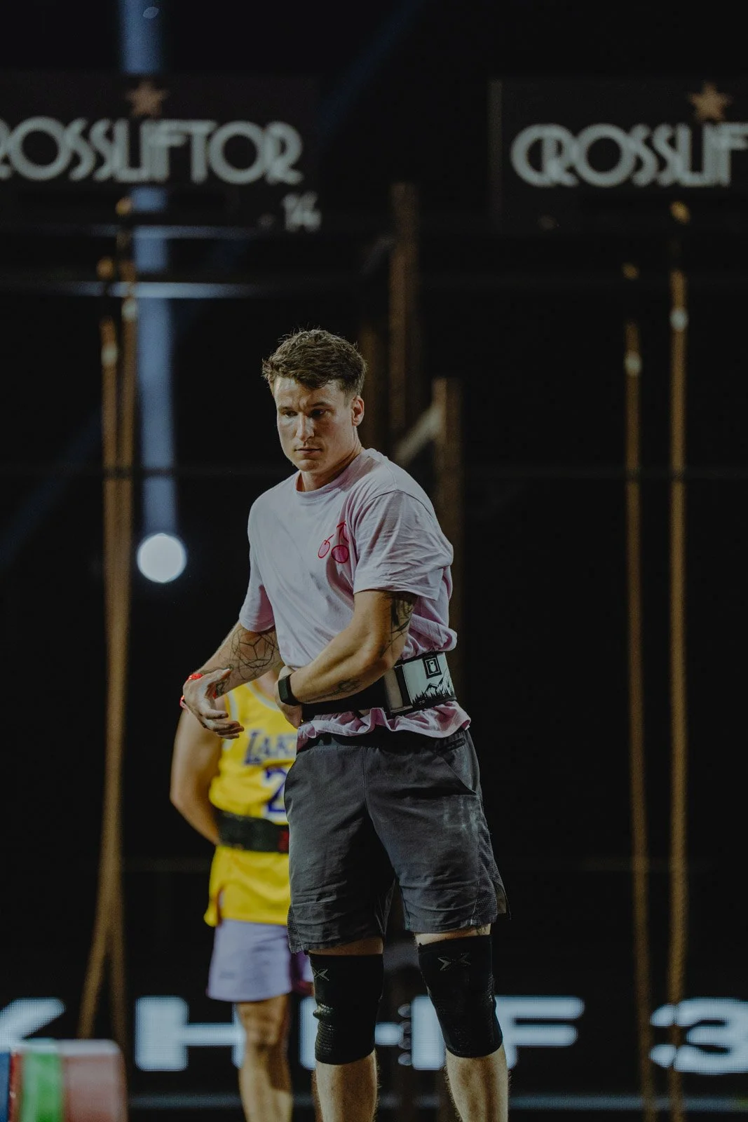 Athlète CrossFit masculin en t-shirt blanc et genouillère lors d'une compétition en salle à Bordeaux — photographe CrossFit Voar by Tim