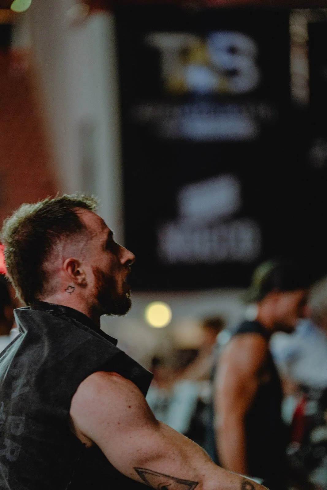 Homme tatoué avec barbe lors d'un événement CrossFit dans une salle sombre à Bordeaux — photographe CrossFit Voar by Tim