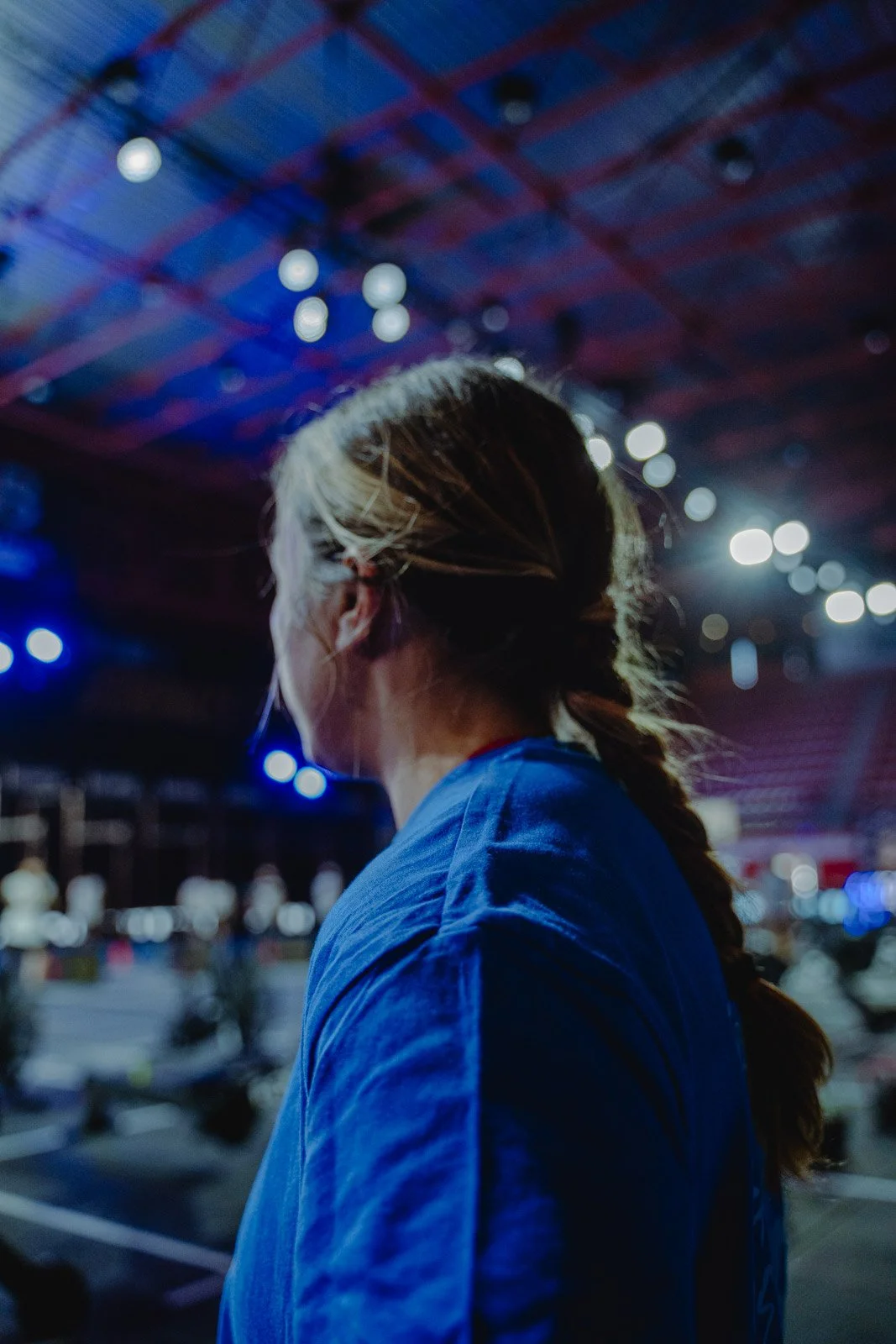 Femme de dos en veste bleue dans une salle CrossFit sombre à Bordeaux — photographe CrossFit Voar by Tim