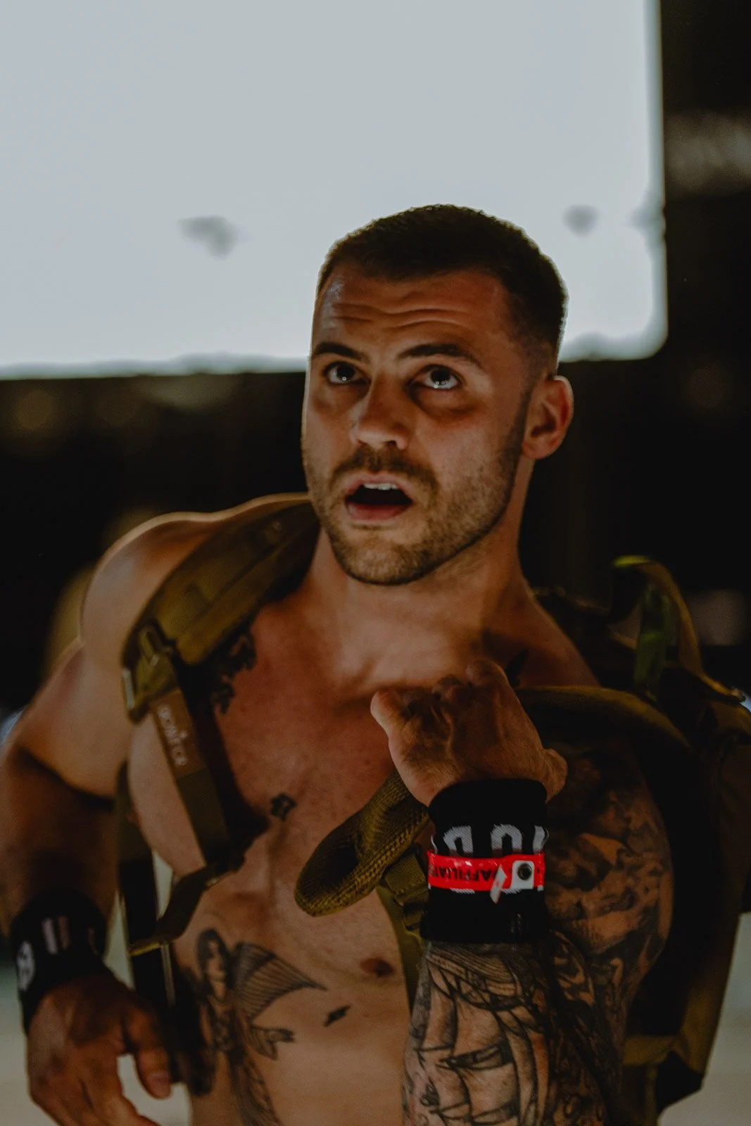 Homme torse nu avec tatouages et sac à dos militaire lors d'une compétition CrossFit Bordeaux — photographe CrossFit Voar by Tim