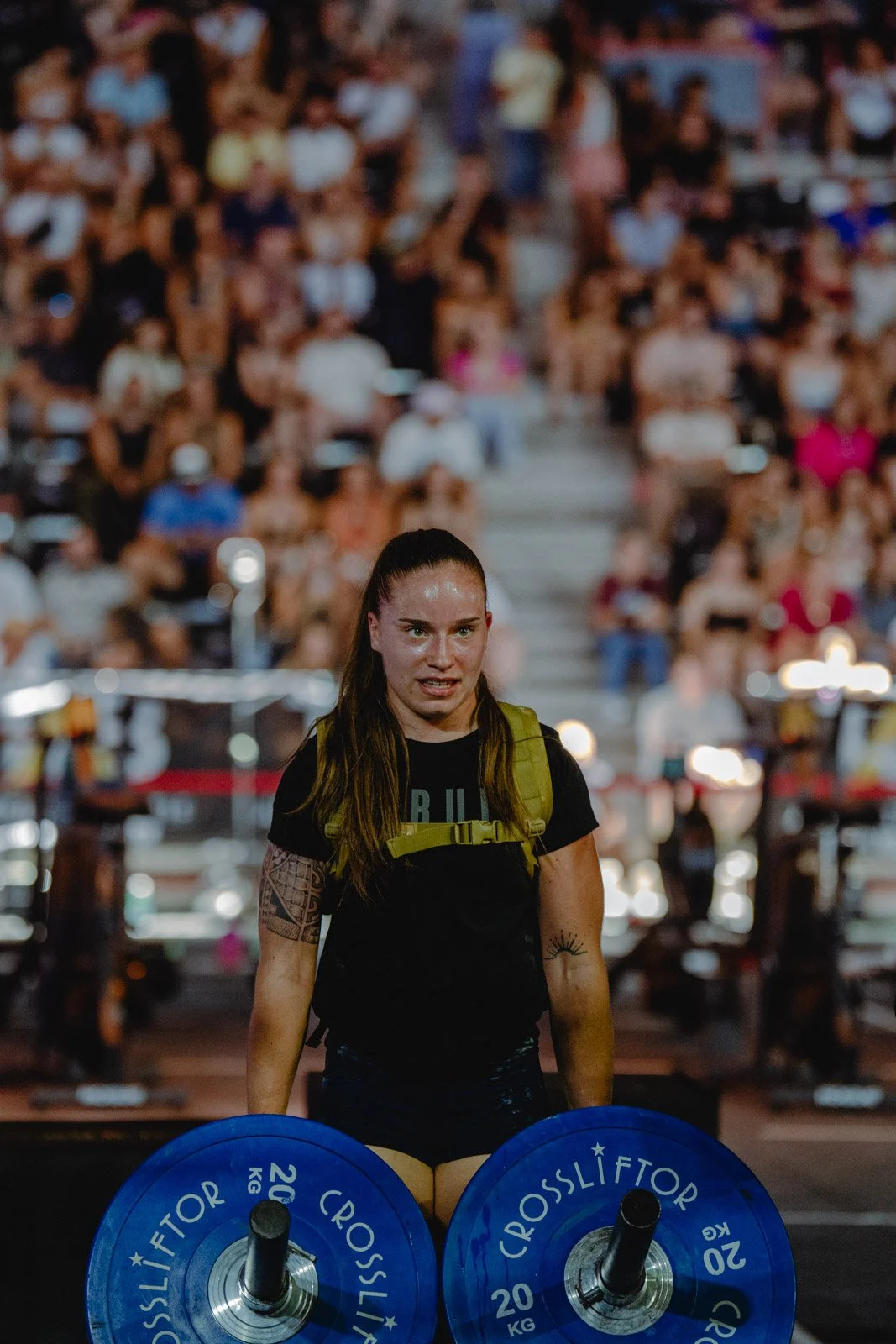 Femme soulevant deux poids lors d'une compétition CrossFit devant le public à Bordeaux — photographe CrossFit Voar by Tim