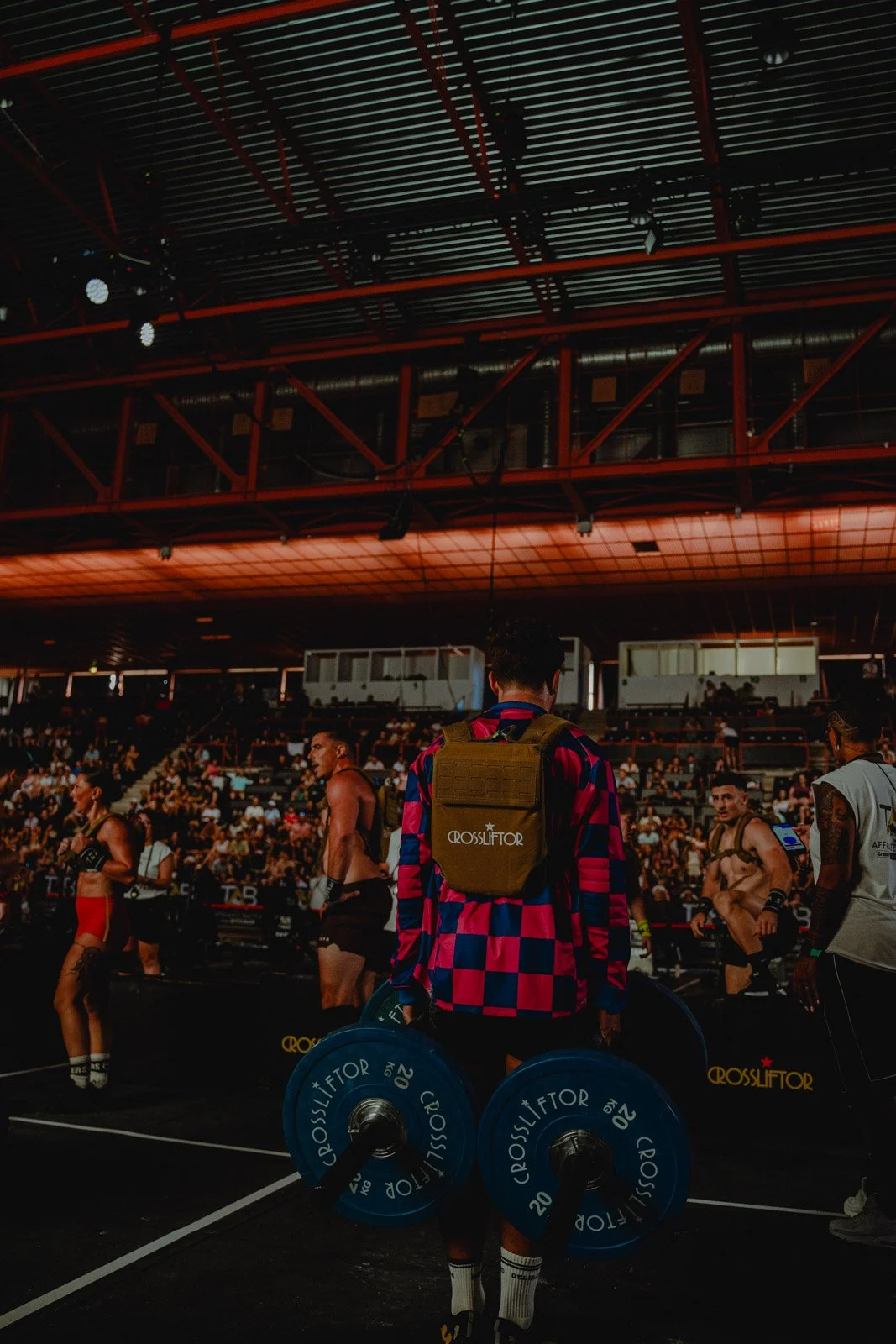 Salle CrossFit avec homme de dos portant sac à dos, entouré d'athlètes à Bordeaux — photographe CrossFit Voar by Tim