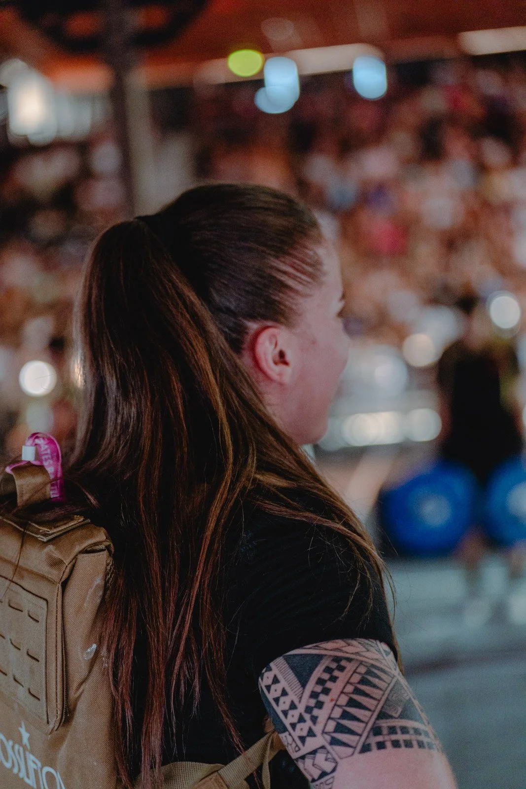 Femme tatouée avec sac à dos beige dans un environnement urbain après séance CrossFit à Bordeaux — photographe lifestyle Voar by Tim