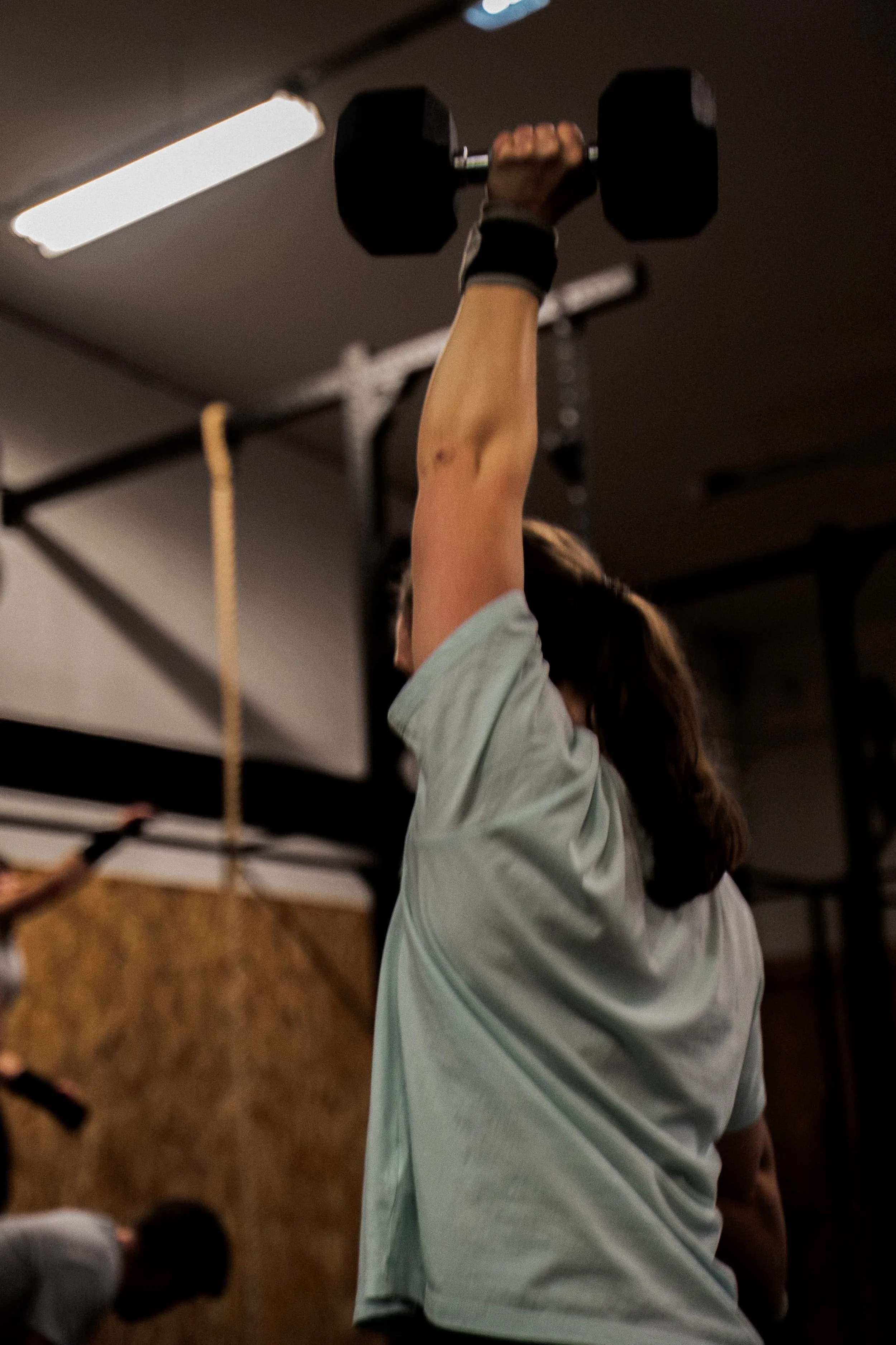 Une personne soulève un haltère dans une salle de sport.