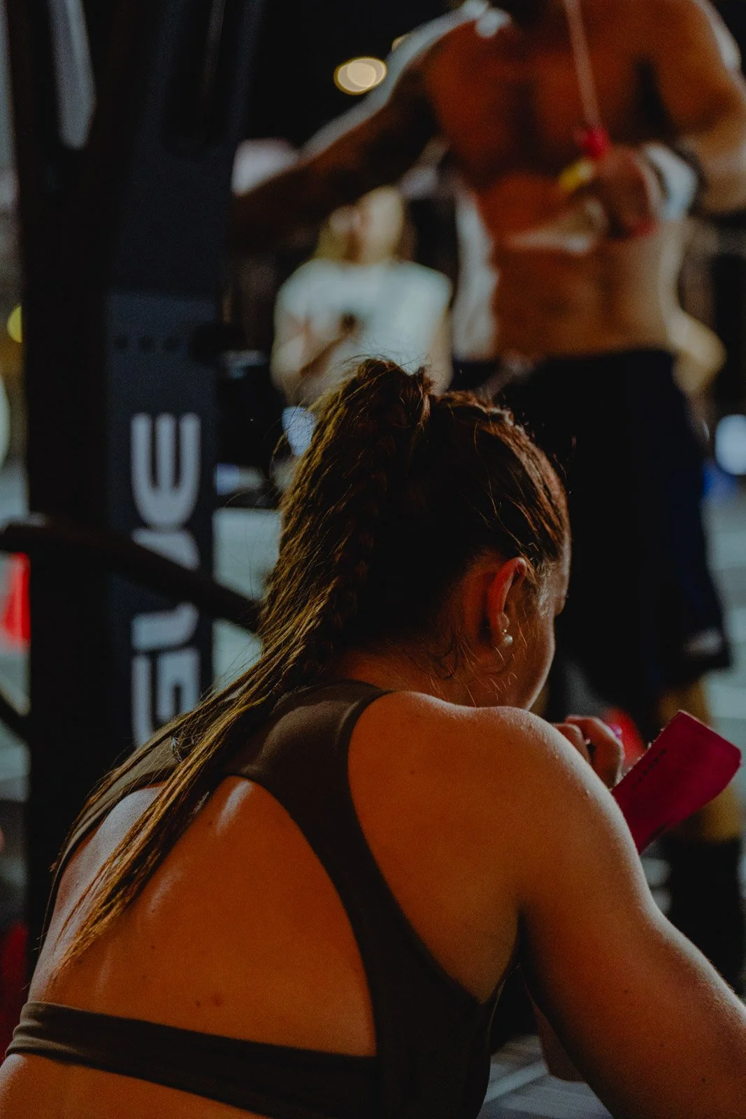 Femme avec tresses consultant son téléphone dans une salle CrossFit en Nouvelle-Aquitaine — photographe CrossFit Voar by Tim