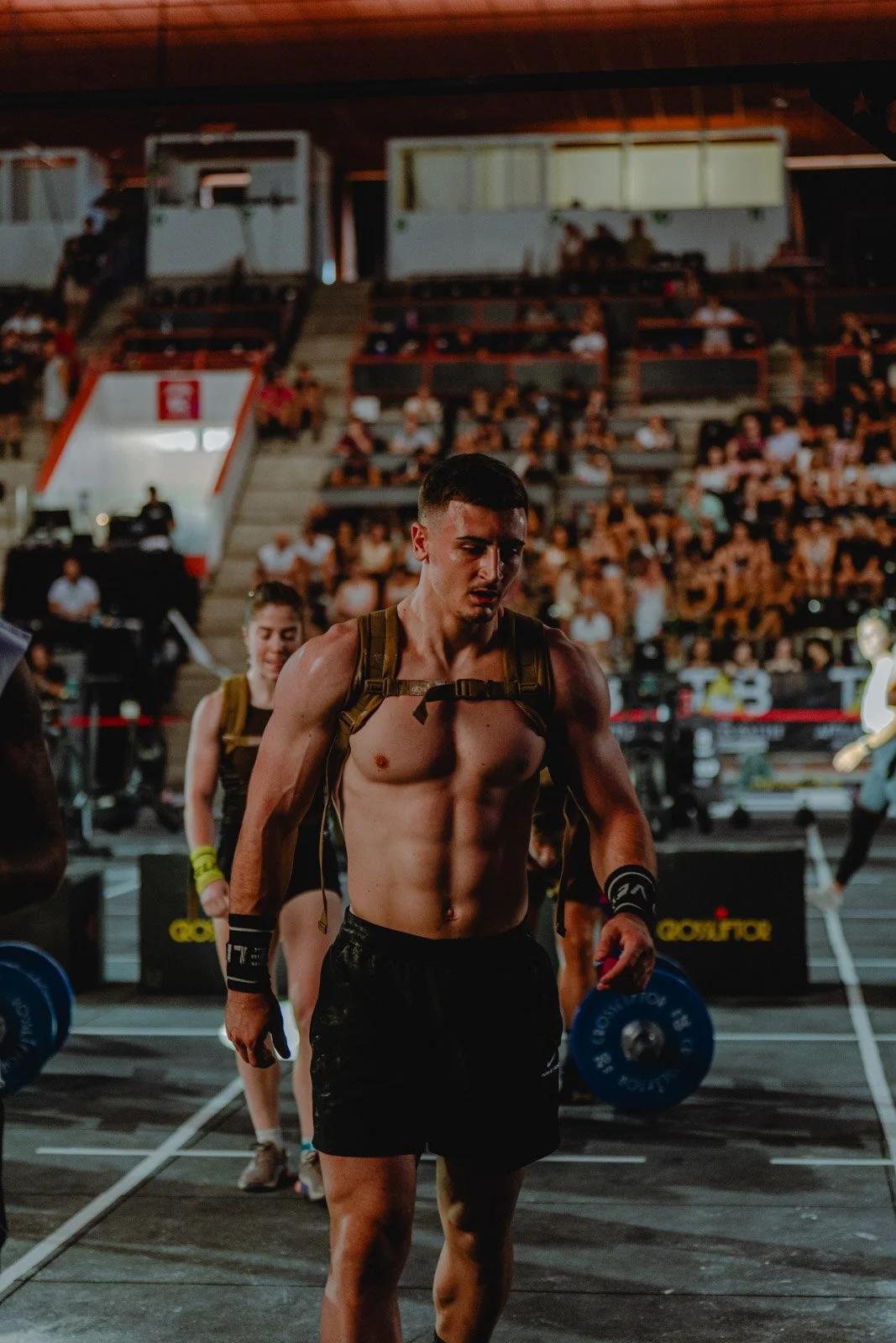 Homme musclé avec sac à dos lors d'une compétition CrossFit devant le public en Nouvelle-Aquitaine — photographe CrossFit Voar by Tim