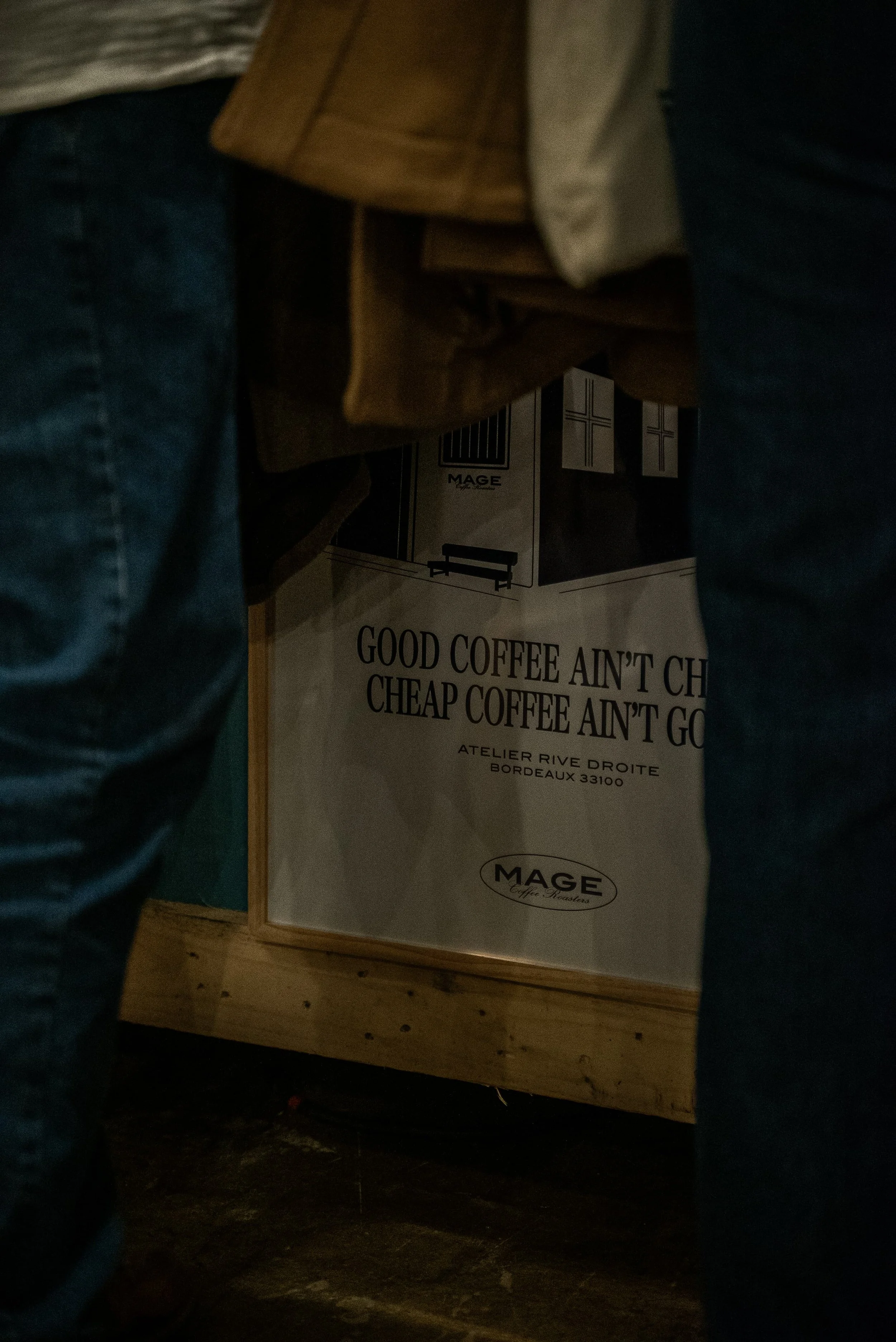 Affiche dans un coin de café ou boutique avec le texte "Good coffee ain't cheap, cheap coffee ain't good", représentant une scène intérieure et une affiche en arrière-plan.