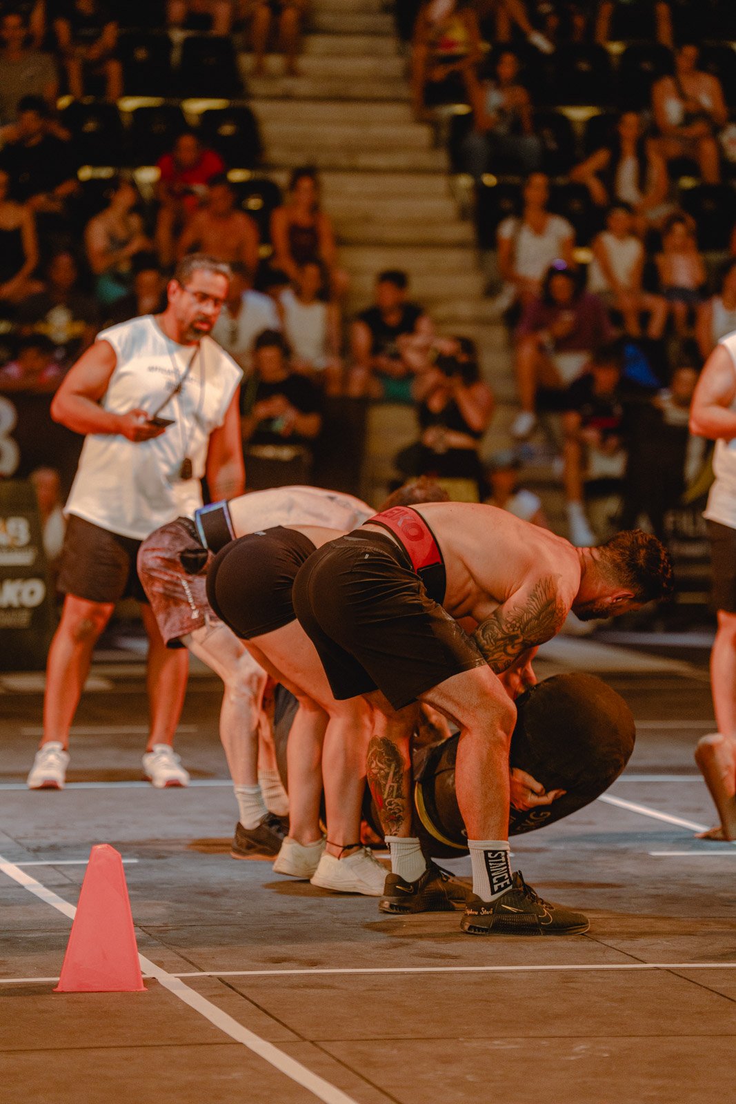 Hommes musclés en position de soulevé de poids lors d'une compétition CrossFit avec public en Nouvelle-Aquitaine — photographe CrossFit Voar by Tim
