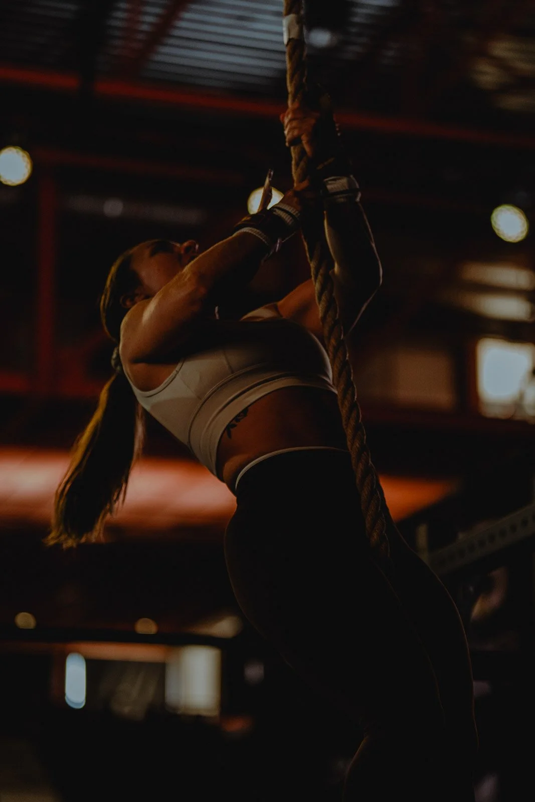 Femme pratiquant la traction sur corde dans une salle CrossFit éclairée, Nouvelle-Aquitaine — photographe CrossFit Voar by Tim