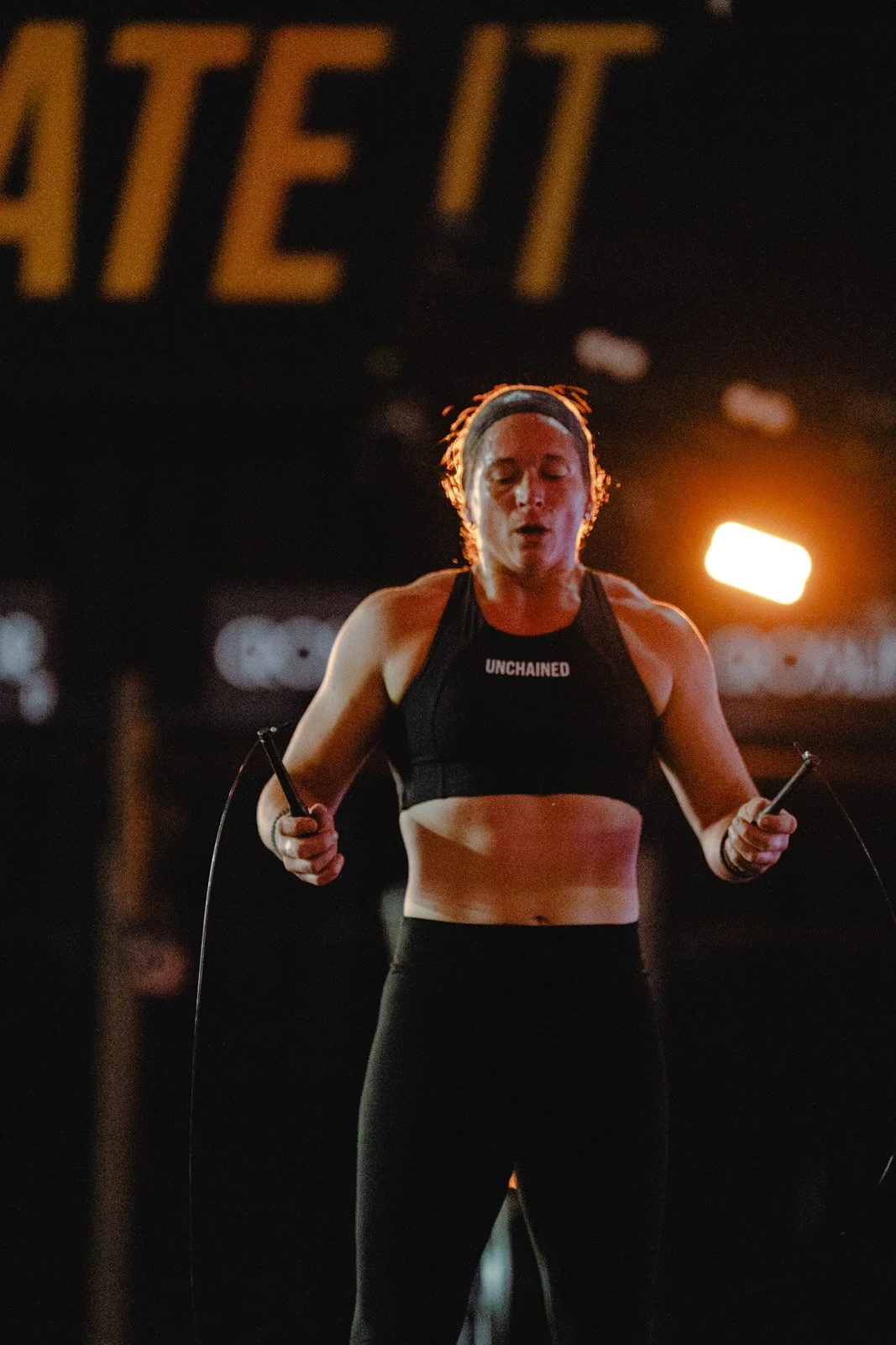 Femme faisant de la corde à sauter la nuit avec haut UNCHAINED, CrossFit à Bordeaux — photographe CrossFit Voar by Tim