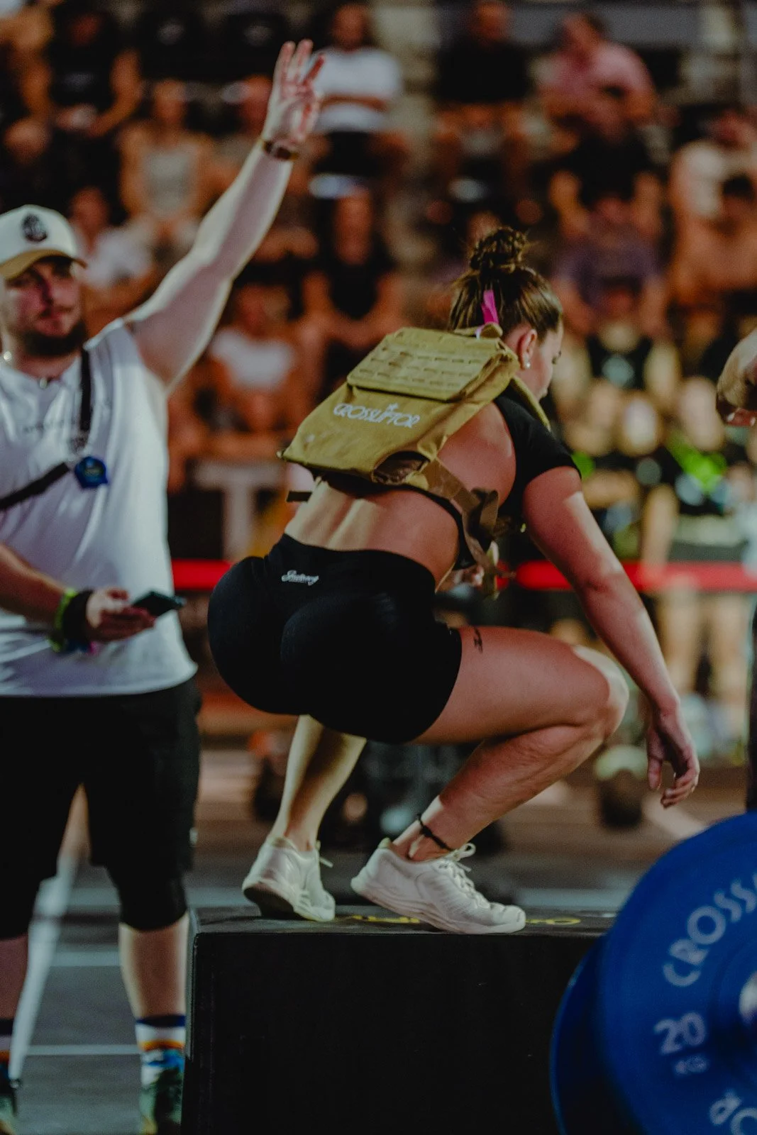 Femme en squat sur plateforme lors d'une compétition CrossFit devant le public à Bordeaux — photographe CrossFit Voar by Tim