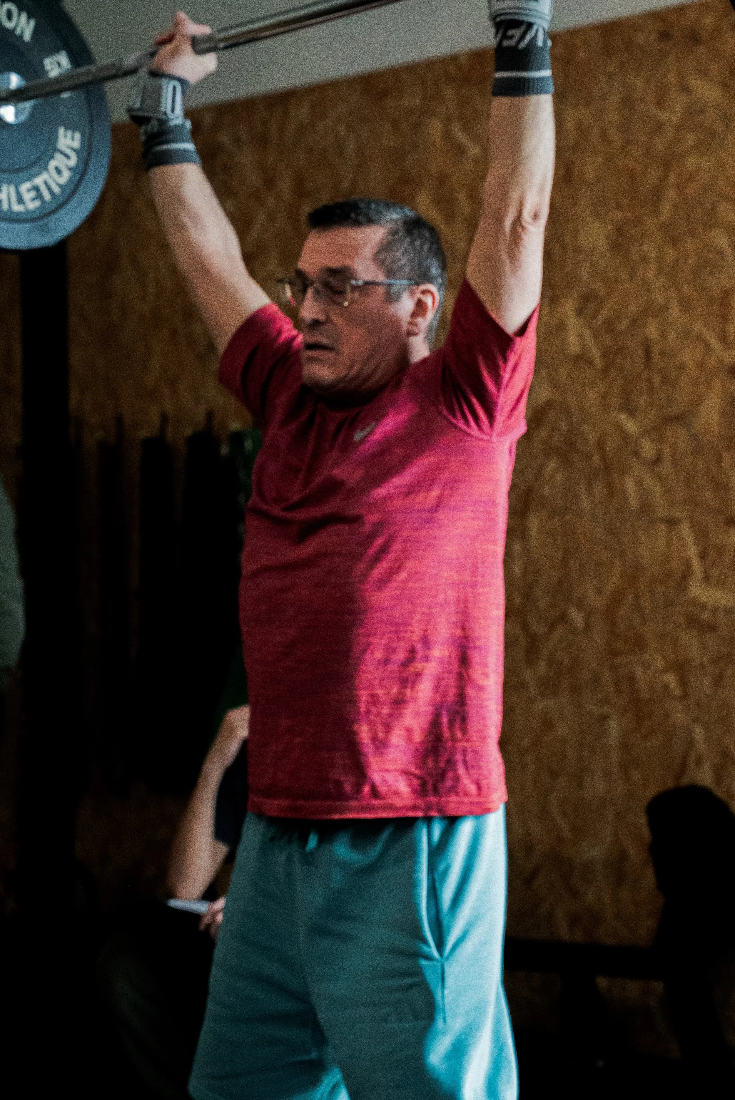 Un homme qui soulève une barre de musculation dans une salle de sport.