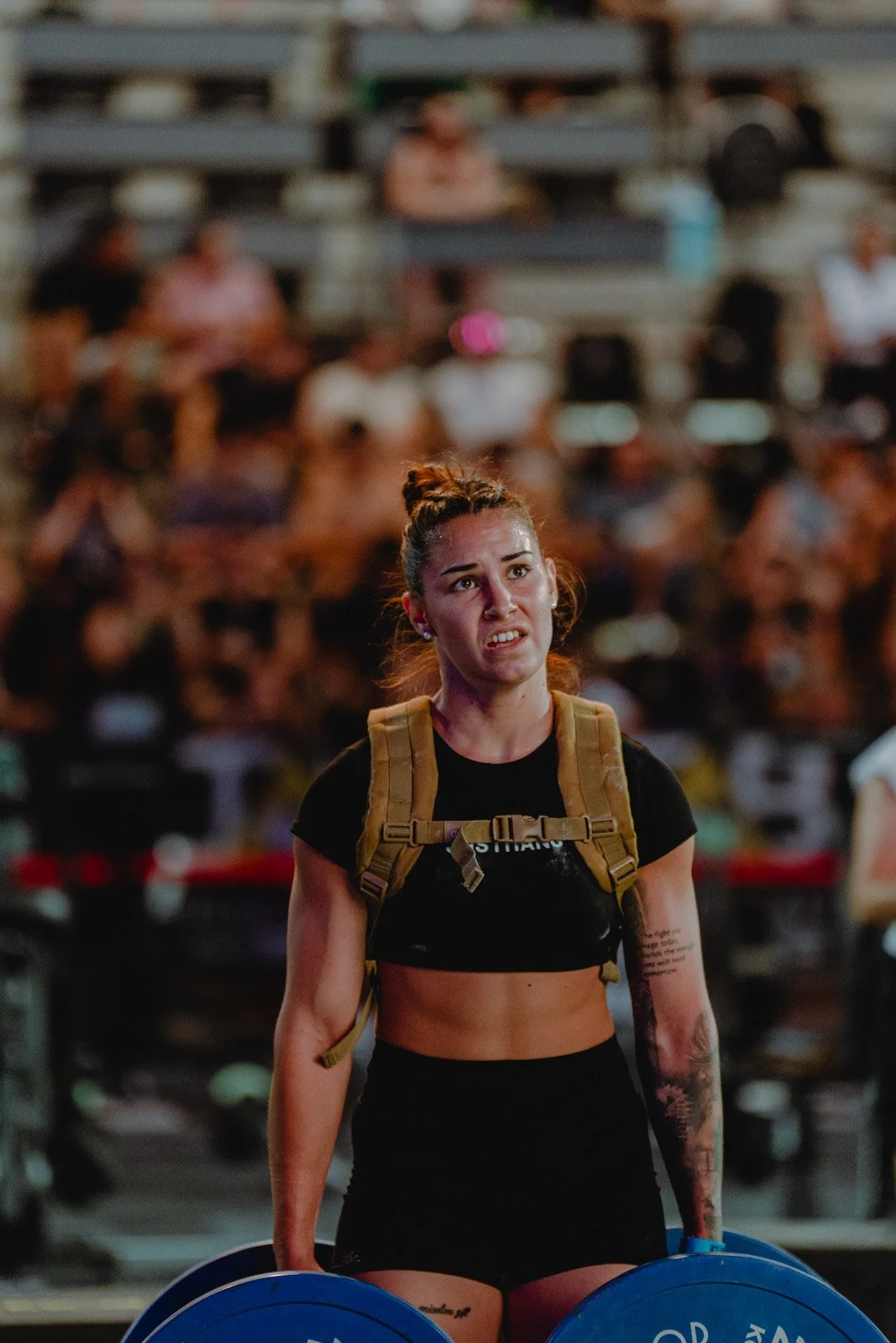 Femme en effort intense tenant une barre de musculation bleue lors d'une compétition CrossFit à Bordeaux — photographe CrossFit Voar by Tim