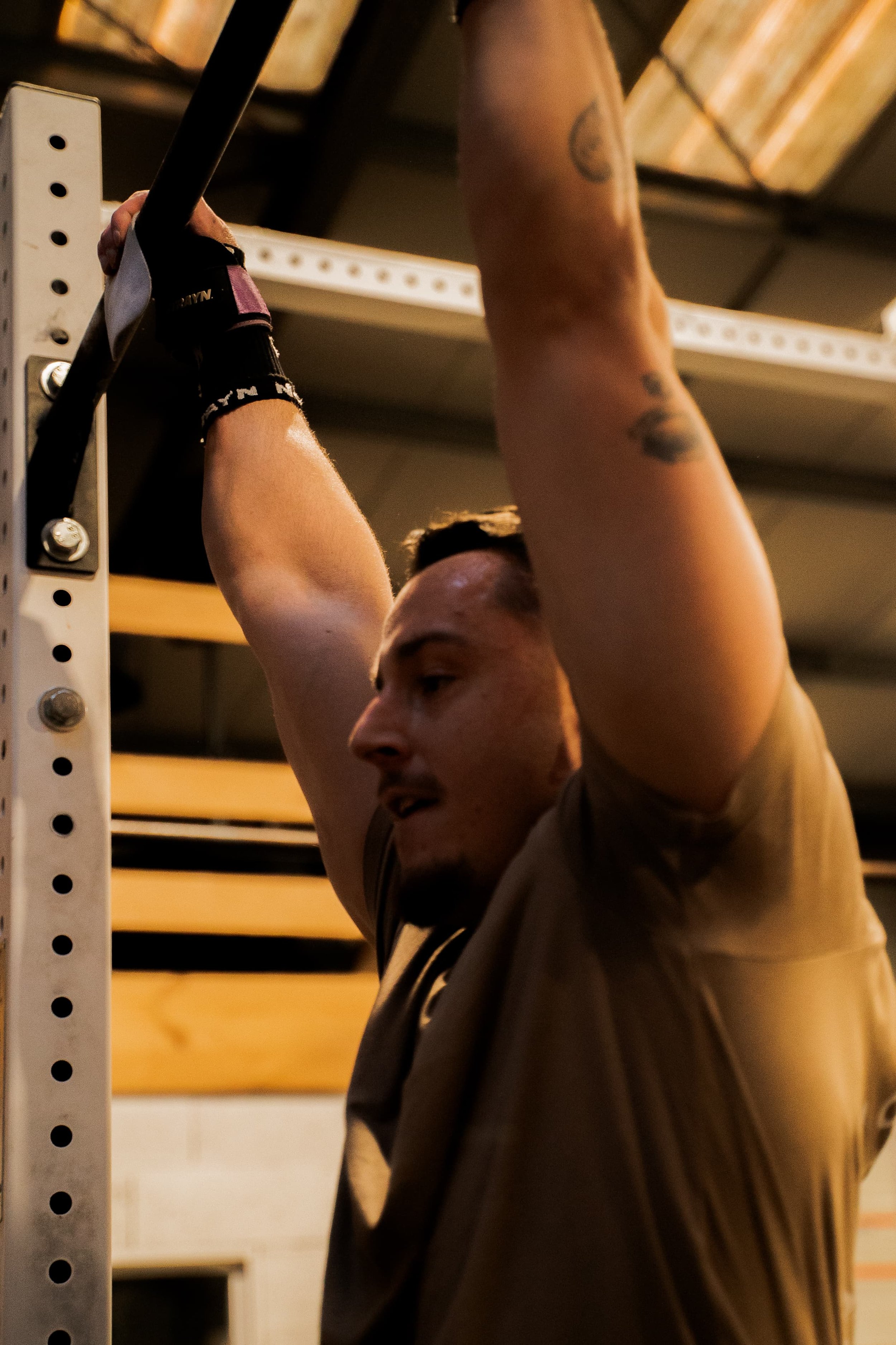 Un homme en train de faire une extension de bras lors d'un entraînement de musculation, avec des tatouages visibles sur ses bras.
