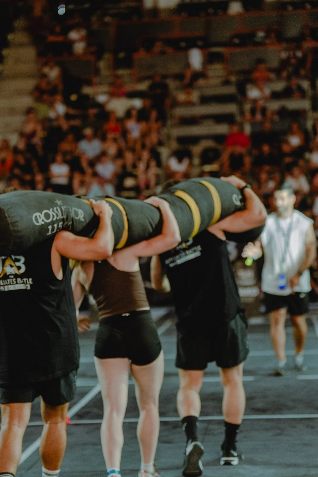 Athlètes portant un grand sac de sport lors d'une compétition CrossFit devant un public — photographe CrossFit Voar by Tim
