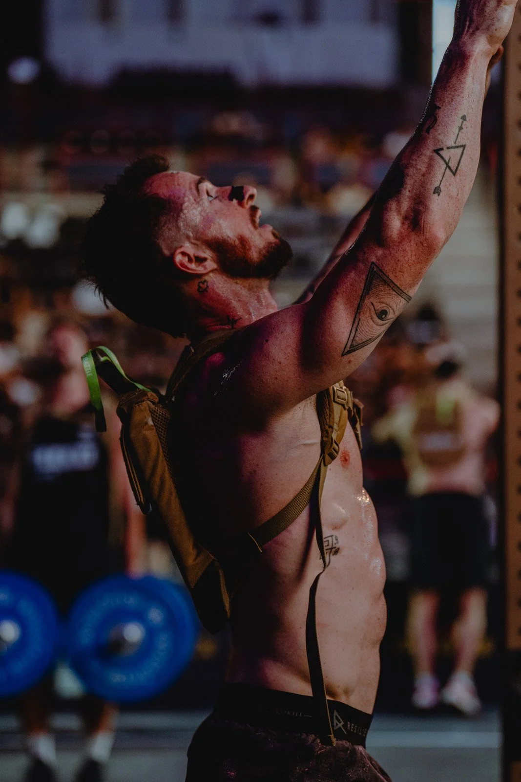 Athlète musclé torse nu levant les bras avec sac à dos dans une salle CrossFit à Chicago — photographe fitness Voar by Tim