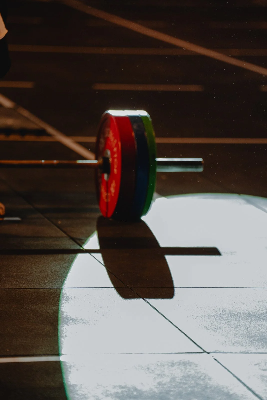 Poids de musculation sur le sol d'une salle CrossFit avec lumière artistique à Bordeaux — photographe CrossFit Voar by Tim