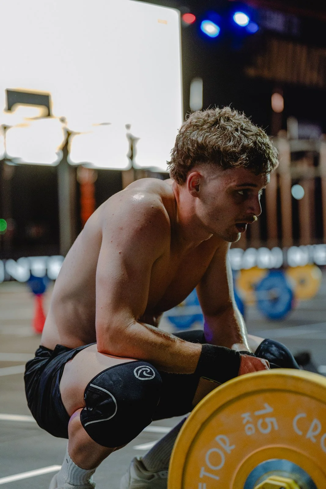 Homme en sueur à genoux dans une salle CrossFit avec poids en arrière-plan en Nouvelle-Aquitaine — photographe CrossFit Voar by Tim