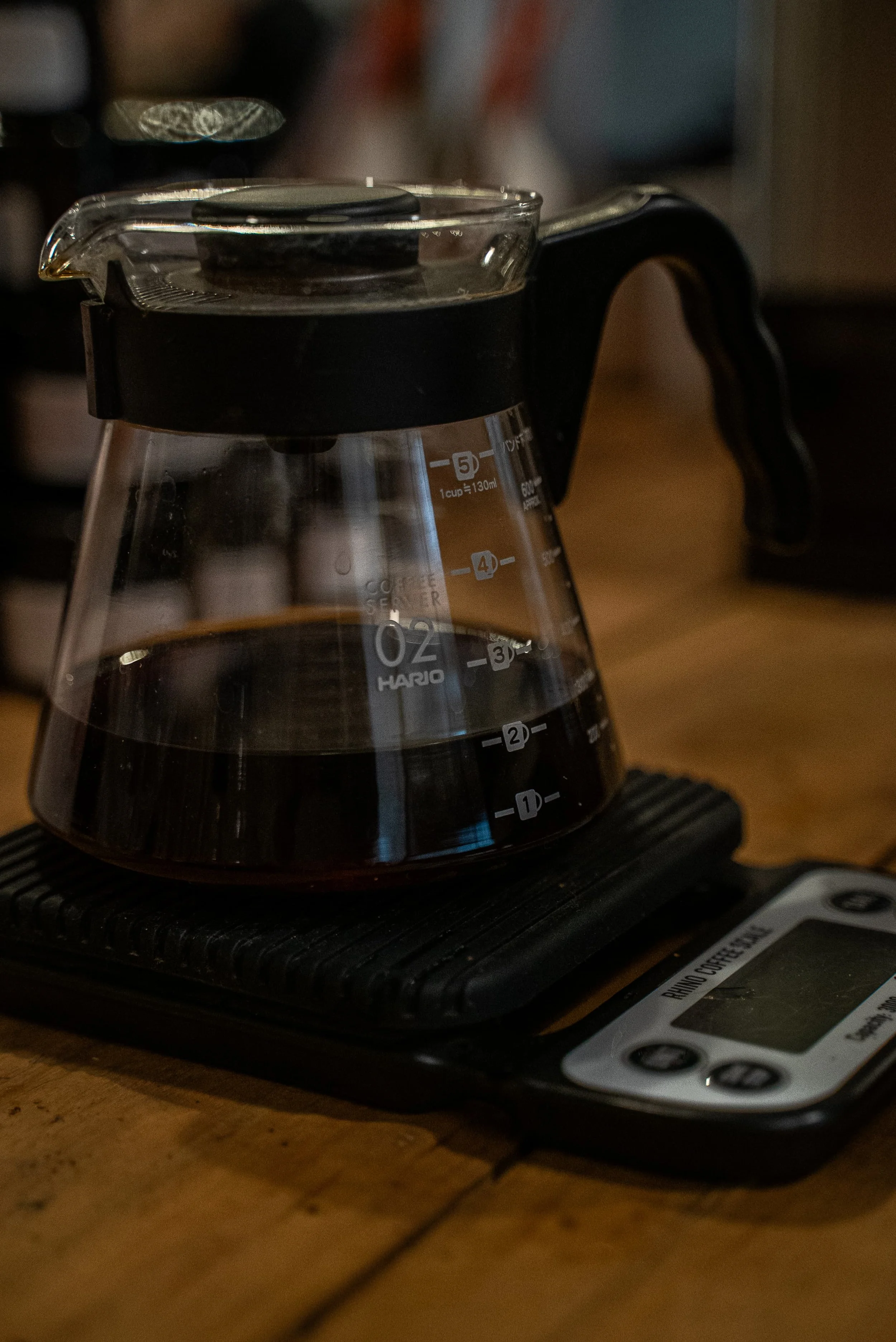 Cafetière à détartrer noire avec un filtre à café placé sur le haut, sur une surface en bois.