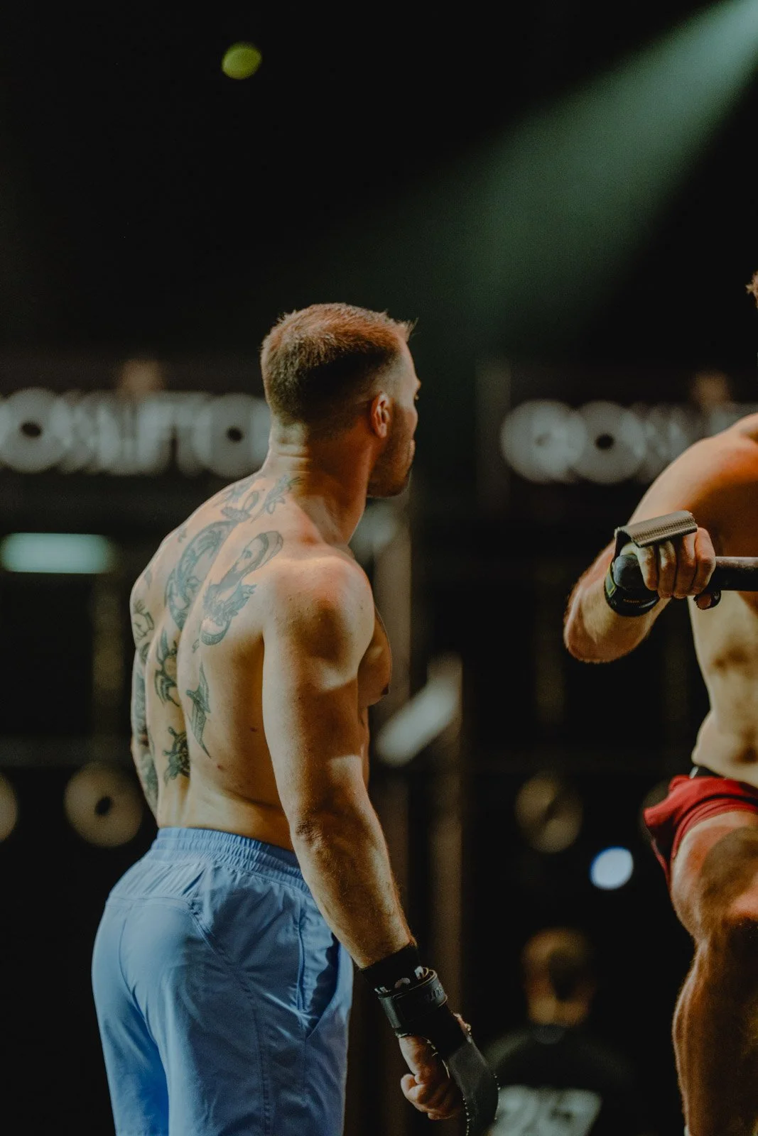 Homme torse nu tatoué supervisant un entraînement de musculation lors d'un événement CrossFit en Nouvelle-Aquitaine — photographe CrossFit Voar by Tim