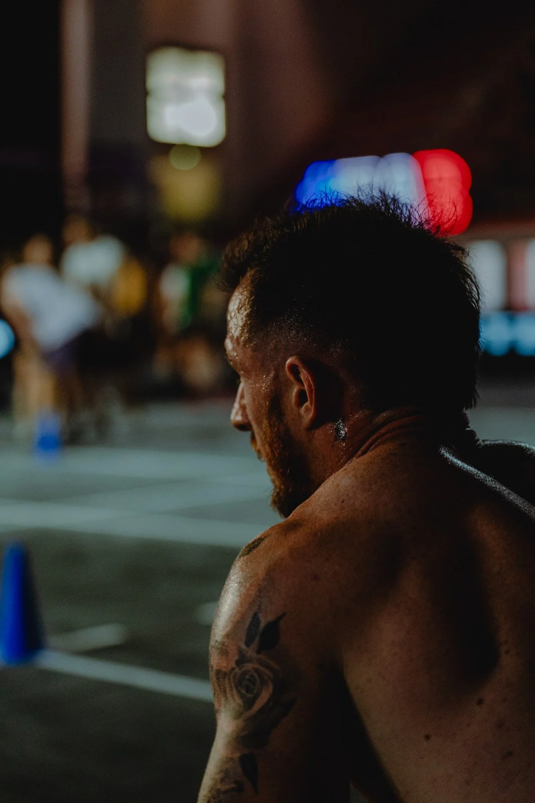 Athlète masculin musclé dans un éclairage dramatique rouge et bleu lors d'une compétition de CrossFit à Bordeaux — photographe sport Voar by Tim